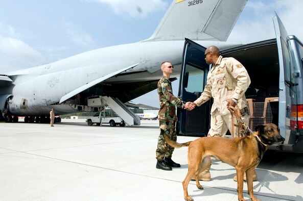 Staff Sgt. Robert Van Hulle (left) says goodbye as Staff Sgt. Markus Hunt and his military working dog, Diego, prepare to board an aircraft at Ramstein Air Base, Germany, on Tuesday, May 9, 2006. Sergeant Van Hulle is the 435th Security Forces Squadron military dog handler liaison. Sergeant Hunt and Diego were returning to Misawa Air Base, Japan, after a six-month tour supporting Operation Iraqi Freedom. (U.S. Air Force photo/Master Sgt. John E. Lasky) 