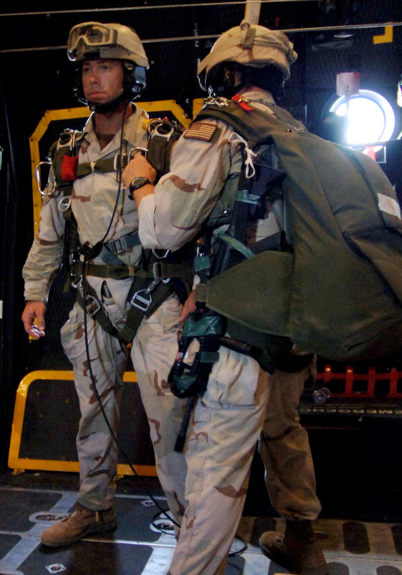 An Air Force pararescueman with the 304th Expeditionary Rescue Squadron checks another PJ's gear before a high-altitude jump over the Gulf of Tadjoura in Djibouti, Africa, on Thursday, May 11, 2006. (U.S. Navy photo/Photographer's Mate 2nd Class Scott Taylor)

