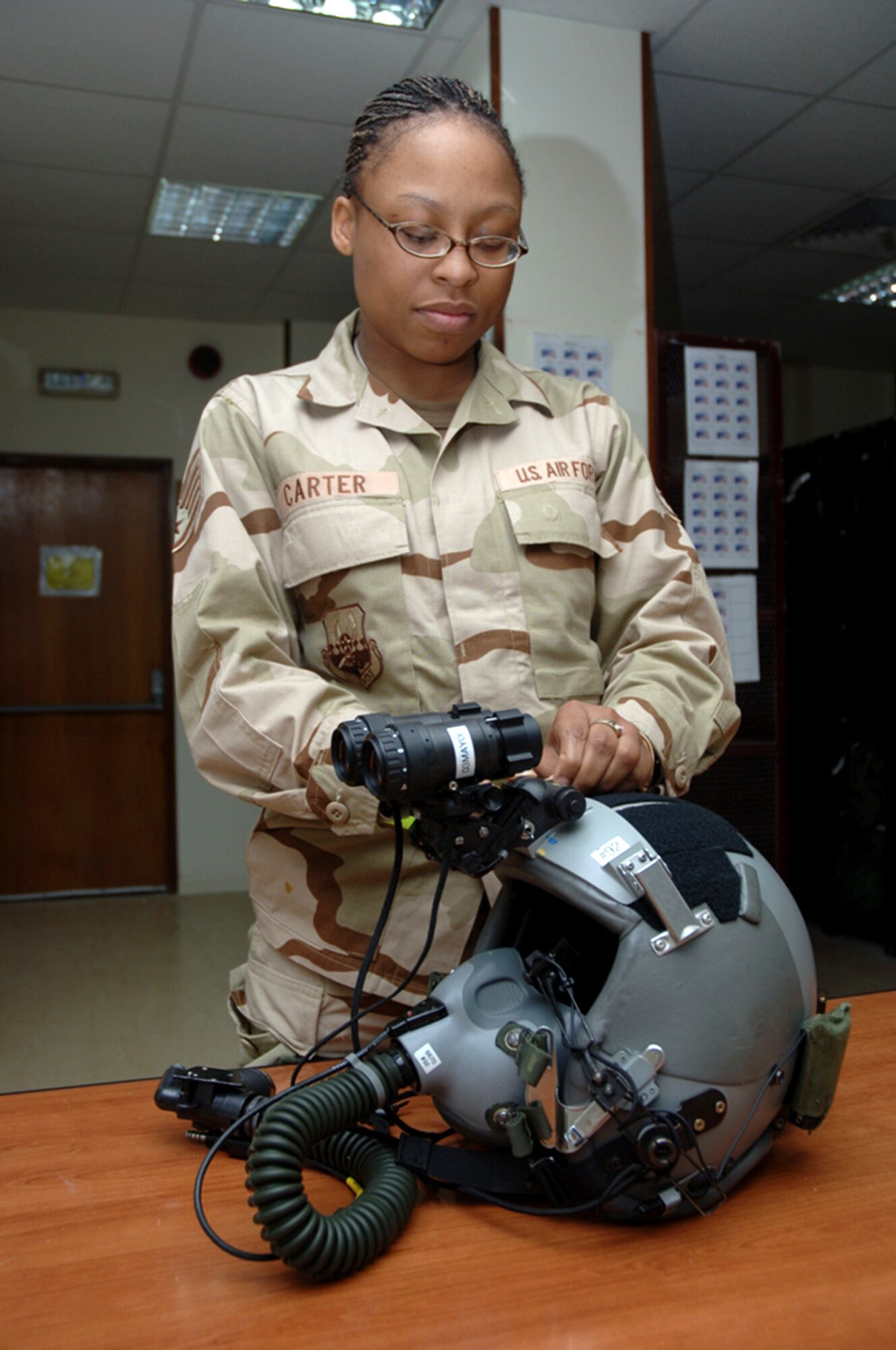 Staff Sgt. Miracle Carter inspects night-vision goggles on a pilot's helmet in the C-130 Hercules life support section. She is a life support specialist assigned to the 379th Expeditionary Operational Support Squadron. (U.S. Air Force photo/Staff Sgt Joshua Strang)
