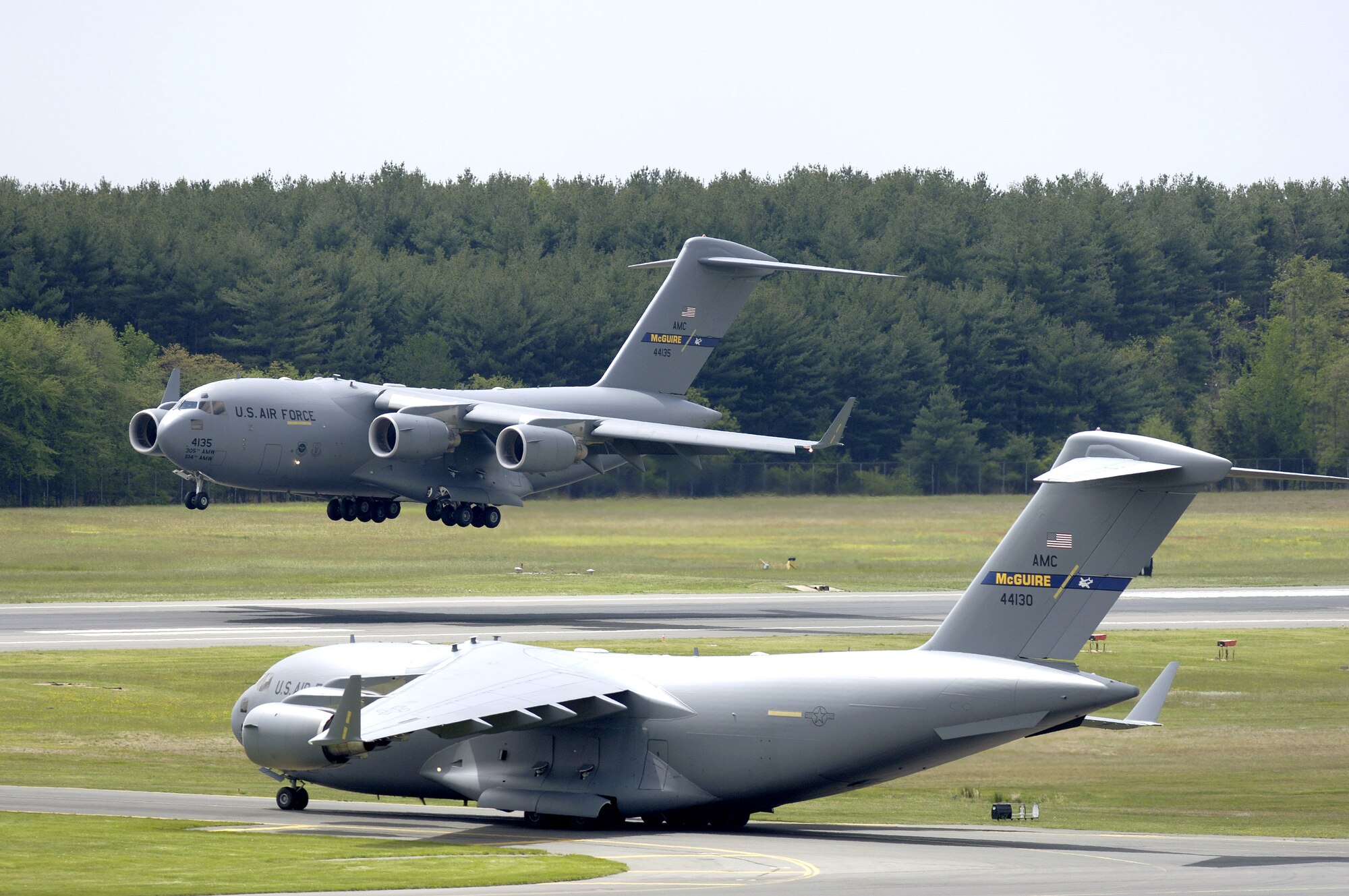A C-17 Globemaster III from the 305th Air Mobility Wing at McGuire Air Force Base, N.J., performs touch and go landings while another C-17 prepares for take-off on Wednesday, May 10, 2006. (U.S. Air Force photo/Brian Dyjak)
