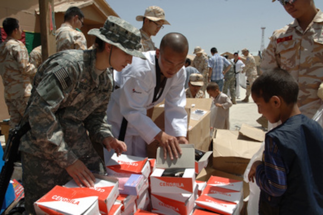 U.S. Army 1st Lt. Valerie Taylor (left) and a Republic of Korea Army soldier (center) look for the right size shoe to give to an Afghan child during a humanitarian mission at the Korean Hospital on Bagram Air Base, Afghanistan, on May 5, 2006. The mission is providing humanitarian services, medical care and education to the local population in Afghanistan. 
