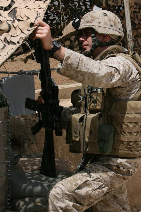 Cpl. Gary M. Cozine, a 21-year-old infantryman with L Company, 3rd Battalion, 8th Marine Regiment talks to his Marines on post at the Veteran Affairs Building in western Ar Ramadi, Iraq. One month ago on 17 April, Cozine was one of many Marines who survived a massive attack on the observation post.  A suicide driven orange dump truck rammed into the building causing a huge explosion tat destroyed a supplementary position on the west flank of the building.