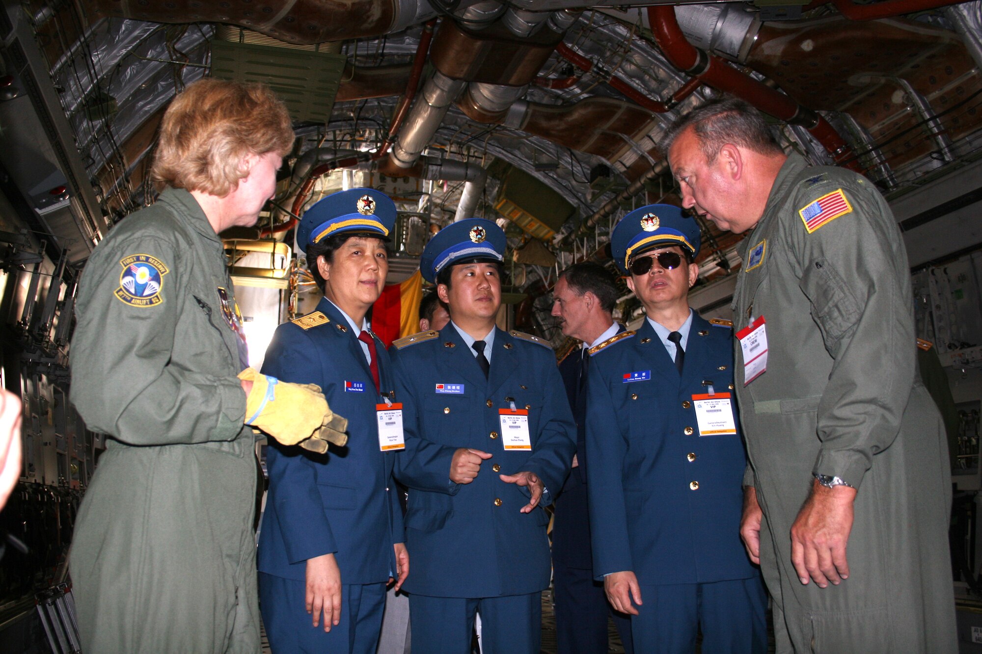 Chief Master Sgt. Evelyn Irwin and Col. Gary Cook discuss the C-17 Globemaster III's cargo load capabilities with members of a Chinese delegation visiting the Berlin Air Show May 16, 2006. The Chinese delegation included (from left center) Maj. Gen. Yue Xicui, Lt. Gen. Huang Xin and Maj. Zhang Dezhao. General Xicui is the Chinese Air Force's first female pilot and has more than 6,000 flying hours.  Various models of U.S. military aircraft and about 60 support personnel from bases in Europe and the United States are attending the air show at Berlin-Schoenefeld Airport May 16-21.  Chief Irwin and Colonel Cook are from the 315th Airlift Wing at Charleston Air Force Base, S.C.  (U.S. Air Force photo/Maj. Pamela A.Q. Cook)