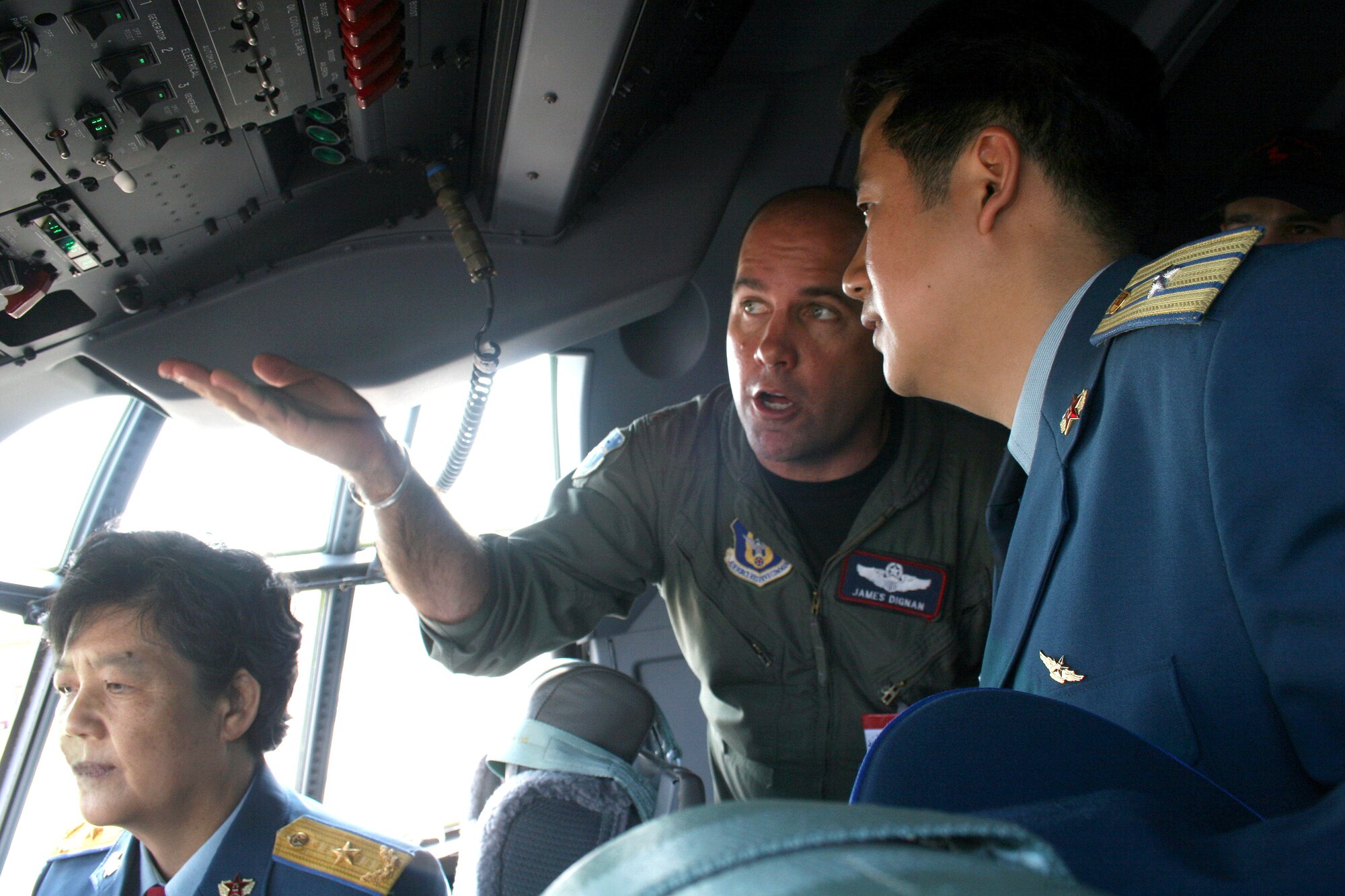 Maj. James Dignan describes some of the features of the C-130J Hercules to Chinese Maj. Gen. Yue Xicui (left) and Maj. Zhang Dezhao on May 16, 2006 at the Berlin Air Show.  General Xicui is the Chinese Air Force's first female pilot and has more than 6,000 flying hours.  Various models of U.S. military aircraft and about 60 support personnel from bases in Europe and the United States are attending the air show at Berlin-Schoenefeld Airport May 16-21.  Major Dignan is a pilot with the 403rd Wing, Keesler Air Force Base, Miss.  (U.S. Air Force photo/Maj. Pamela A.Q. Cook)