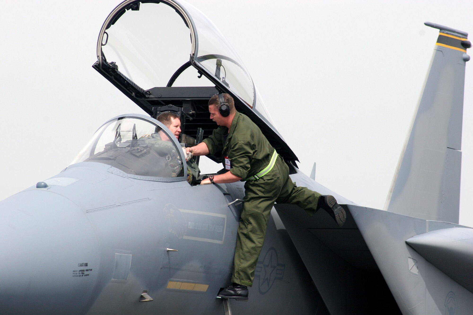 Air Force Lt. Col. Steve Neuser is greeted by a German crew chief shortly after he arrived in his F-15 Eagle at the Berlin Air Show on May 15, 2006. Various models of U.S. military aircraft and about 60 support personnel from bases in Europe and the United States are attending the air show at Berlin-Schoenefeld Airport May 16-21. Colonel Neuser is a pilot with the 493rd Fighter Squadron at Royal Air Force Lakenheath, England. (U.S. Air Force photo/Maj. Pamela A.Q. Cook)
