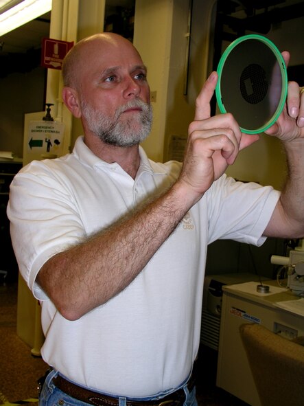 WRIGHT-PATTERSON AIR FORCE BASE, Ohio -Dr. James Scofield of the Air Force Research Laboratory Propulsion Directorate's Electrical Technology and Plasma Physics Branch inspects a Schottky diode.  He received the 2006 Federal Laboratory Consortium Award for Excellence in Technology Transfer for pioneering the new and improved silicon carbide (SiC) Schottky diodes.  (Air Force photo)

