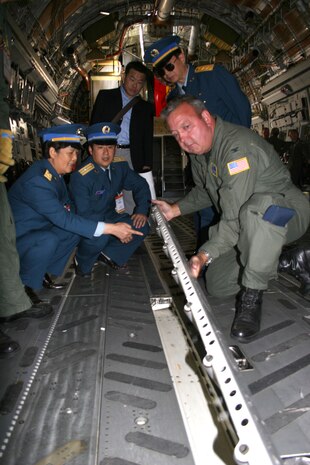 BERLIN, Germany - Col. Gary Cook, 315th Airlift Wing commander at Charleston Air Force Base, S.C., discuss the C-17's cargo load capabilities with Chinese Maj. Gen. Yue Xicui and Chinese Lt. Gen. Huang Xin at the Berlin Air Show May 16. Xicui is the Chinese Air Force's first female pilot and has more than 6,000 flying hours. The Chinese delegation also visited the B-1 Lancer and C-130J Hercules aircraft. Various models of U.S. military aircraft and about 60 support personnel from bases in Europe and the United States are attending the air show at Berlin-Schoenefeld Airport May 16-21. The Berlin Air Show is one of the premier events of its type in the world, and U.S. military participation contributes to a number of U.S. security and foreign policy interests. Participation promotes standardization and interoperability of equipment with our NATO allies and other potential coalition partners, highlights the strength of the U.S. commitment to the security of Europe and demonstrates that U.S. industry is producing equipment that will be critical to the success of current and future military operations.  (Photo by Maj. Pamela A.Q. Cook, USAF)
