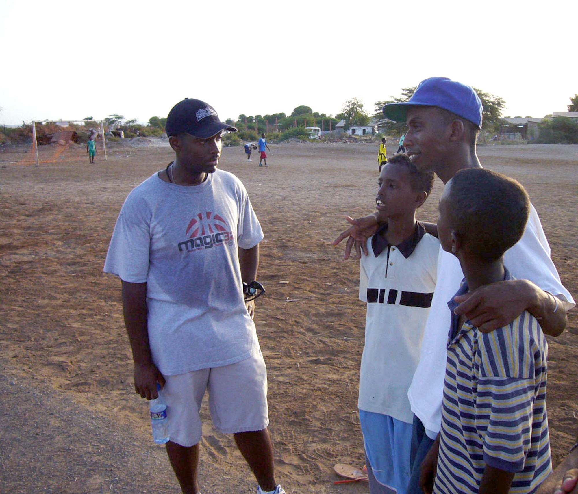 Air Force Capt. Brian Brasher speaks with Mohammed and two children at a boys' orphanage in Djibouti, Africa, May 15, 2006.  Servicemembers assigned to Combined Joint Task Force-Horn of Africa regularly visit local orphanages to share experiences and spend time with the children. (U.S. Air Force photo/Capt. Martin Gerst)