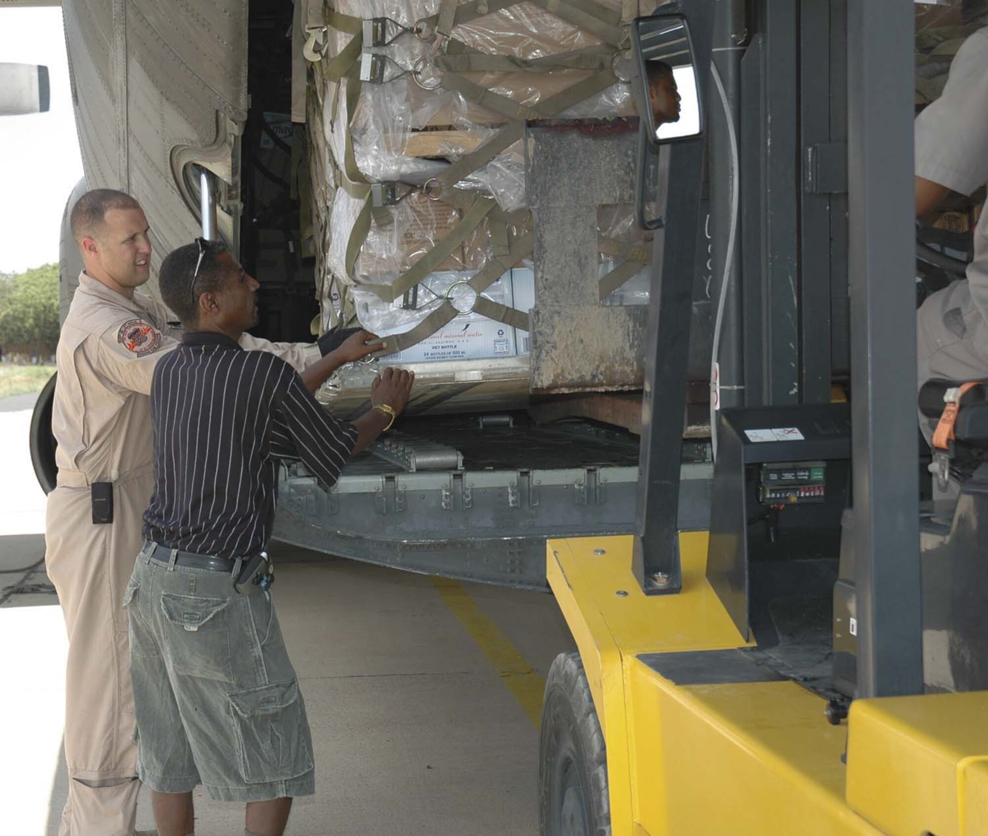 746th AEW crew chief Senior Airman Chris Sutton helps a local man unload humanitarian supplies in Kenya. (Maj. Ann Peru Knabe)