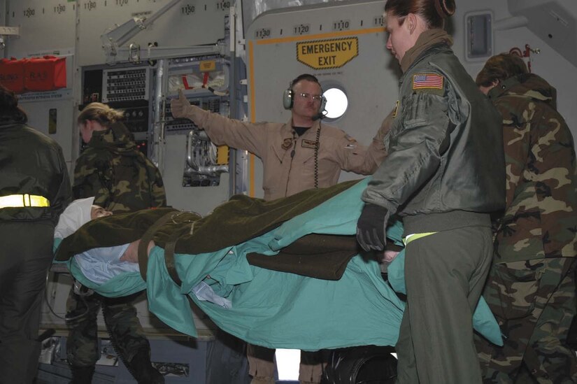 Maj. Gerard Hogan of the 315th Aeromedical Evacuation Squadron, Charleston Air Force Base, S.C., directs the movement of a wounded Soldier being transferred from Iraq to Germany aboard a C-17 Globemaster III. Air Force aeromedical evacuation crews have conducted more than 55,000 patient moves since the beginning of Operation Iraqi Freedom, caring for a wide range of ailments. Nearly 88 percent of the 400 aeromedical evacuation people working worldwide are in Air Force Reserve Command or the Air National Guard, said Lt. Gen. George Taylor, Air Force surgeon general. The 791st Expeditionary Aeromedical Evacuation Squadron at Ramstein Air Base, Germany, the hub for patient movements in Europe and Southwest Asia, is more than 50 percent manned by reserve component people. (1st Lt. Wayne Capps)