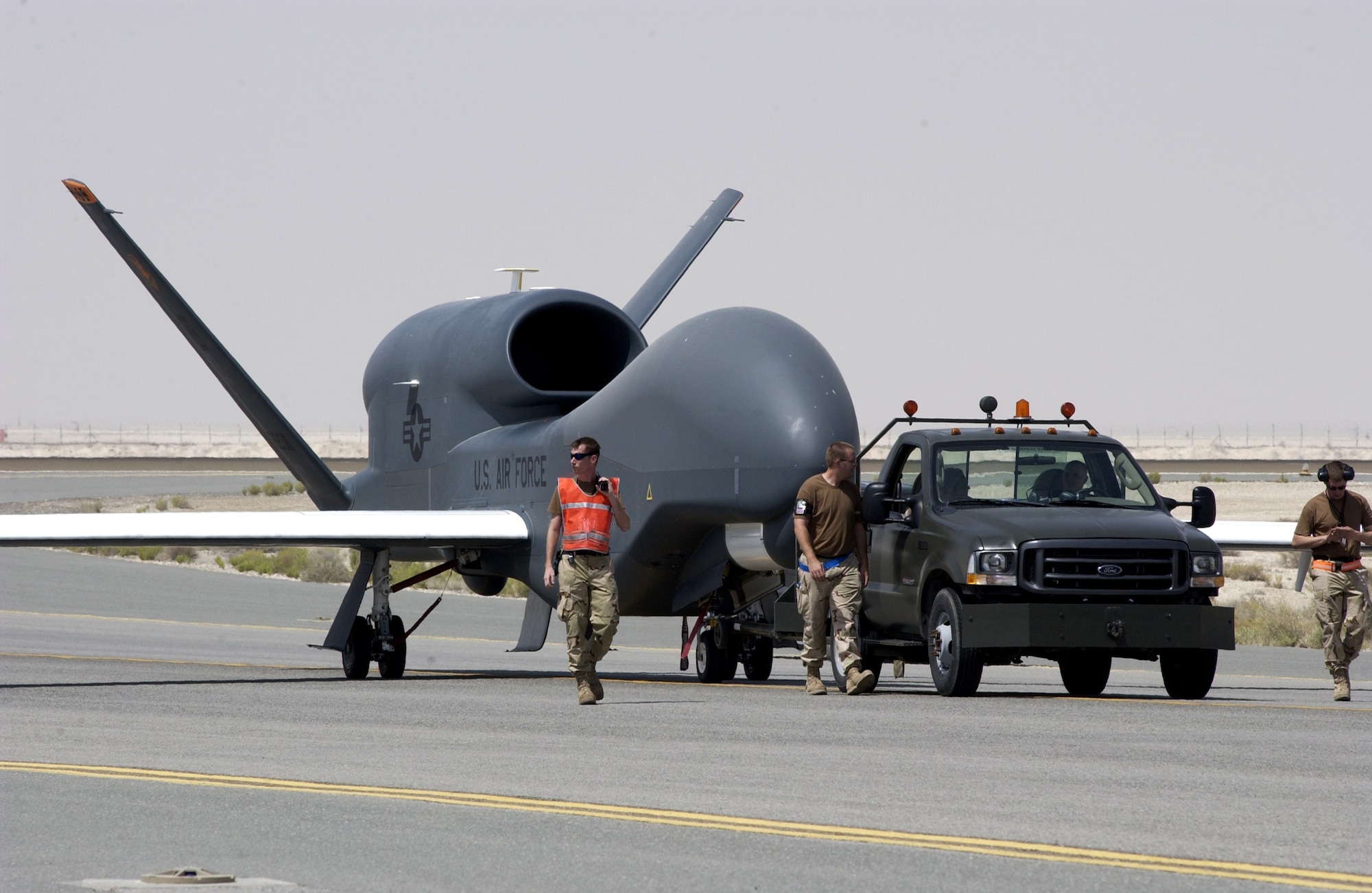 A Global Hawk maintenance team tows an unmanned Global Hawk aircraft at a theater in Southwest Asia. The aircraft has collected more than 96 percent of the target deck – nearly five thousand images of enemy locations, resources and personnel. (U.S. Air Force photo/Staff Sgt. Christopher Matthews)