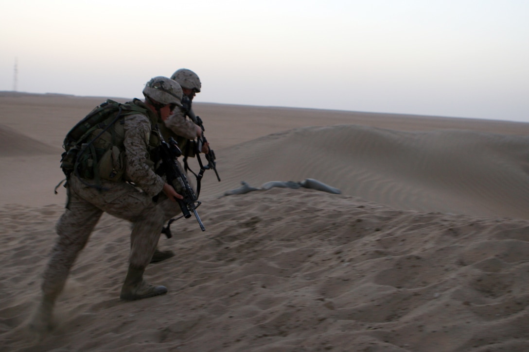 Marines with Golf Company, Battalion Landing Team 2/5, 15th Marine Expeditionary Unit, advance on an objective during grenade training in the wide-open Kuwaiti desert outside Camp Buehring, Kuwait.  ::r::::n::   Golf Company took advantage of the wide-open desert of Northern Kuwait to conduct training with grenades, close quarters combat and rocket fire.::r::::n::   The Camp Pendleton, Calif. based 15th MEU is comprised of approximately 2,200 Marines and Sailors and is a forward deployed force of readiness capable of conducting numerous operations, such as Non-Combatant Evacuation Operations, Humanitarian Assistance Operations and a wide range of amphibious missions. ::r::::n::   The 15th MEU is currently conducting sustainment training at Camp Buehring, Kuwait. (Official USMC photo by Lance Cpl. Timothy T. Parish) (Released)::r::::n::