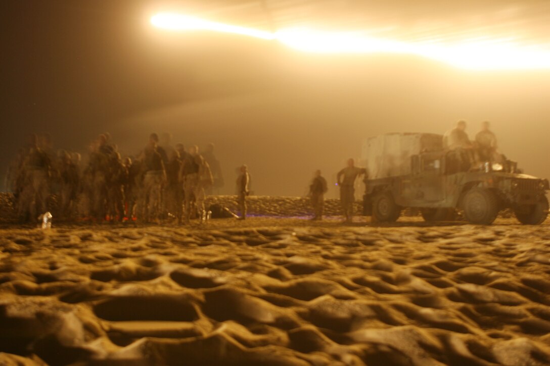 Marines with Golf Company, Battalion Landing Team 2/5, 15th Marine Expeditionary Unit, wait to run the grenade course while an M-127 A1 white star illumination parachute lights the wide-open desert during training outside Camp Buehring, Kuwait.  ::r::::n::   Golf Company took advantage of the wide-open desert of Northern Kuwait to conduct training with grenades, close quarters combat and rocket fire.::r::::n::   The Camp Pendleton, Calif. based 15th MEU is comprised of approximately 2,200 Marines and Sailors and is a forward deployed force of readiness capable of conducting numerous operations, such as Non-Combatant Evacuation Operations, Humanitarian Assistance Operations and a wide range of amphibious missions. ::r::::n::   The 15th MEU is currently conducting sustainment training at Camp Buehring, Kuwait. (Official USMC photo by Lance Cpl. Timothy T. Parish) (Released)::r::::n::::r::::n::