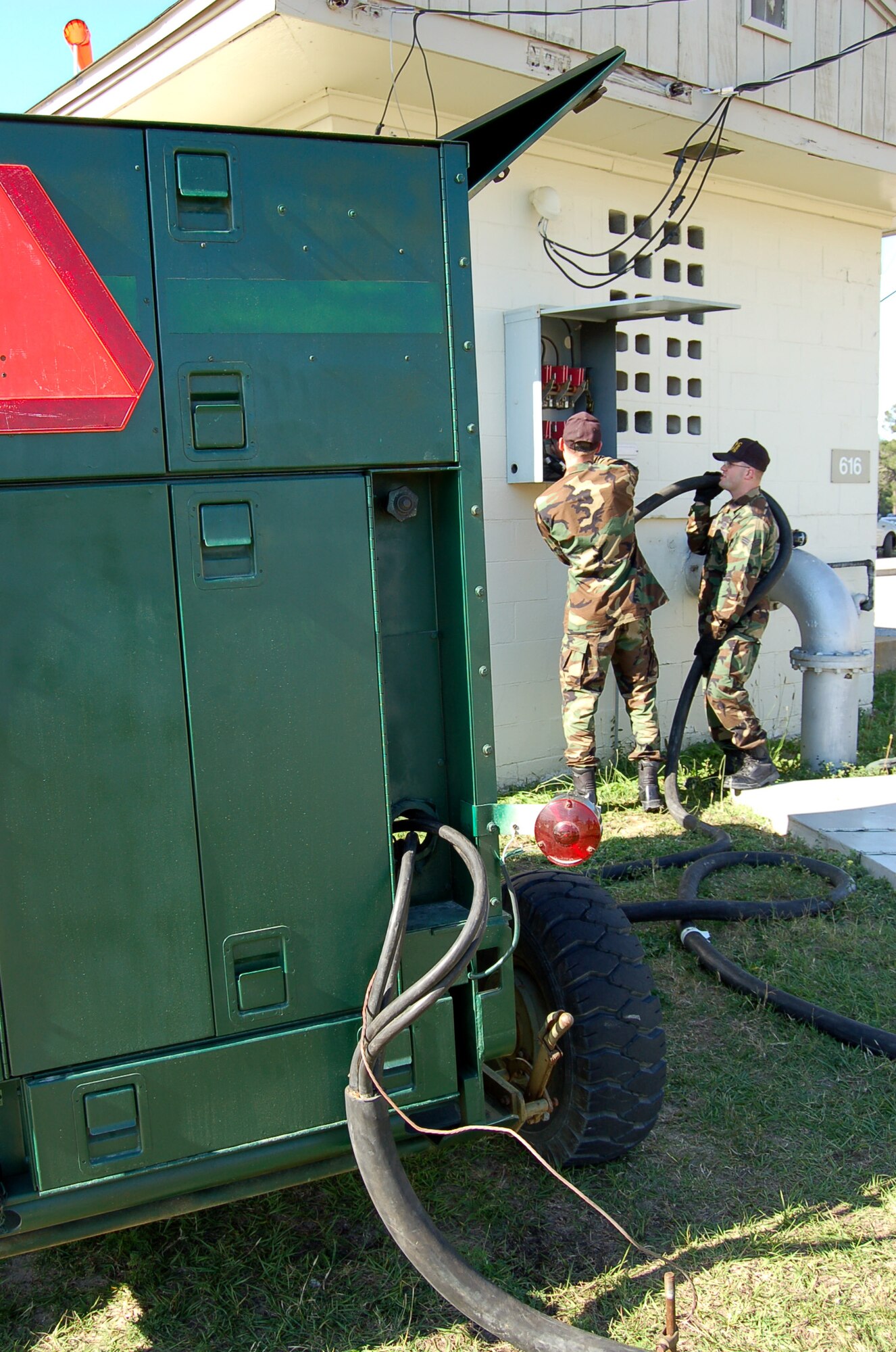 Airman 1st Class Jeb Carter, left, hooks up a mobile generator to a building with help from Senior Airman Royal Archer at Eglin Air Force Base, Fla., on Wednesday, May 17, 2006. The electrical power production troops with the 796th Civil Engineer Squadron generator section practice setting up generators in case a powerful storm cuts their commercial power. Eglin held a three-day exercise May 15 through May 17, called "Hurricane Lisette," to prepare for the next big storm. (U.S. Air Force photo/Master Sgt. Timothy P. Barela)