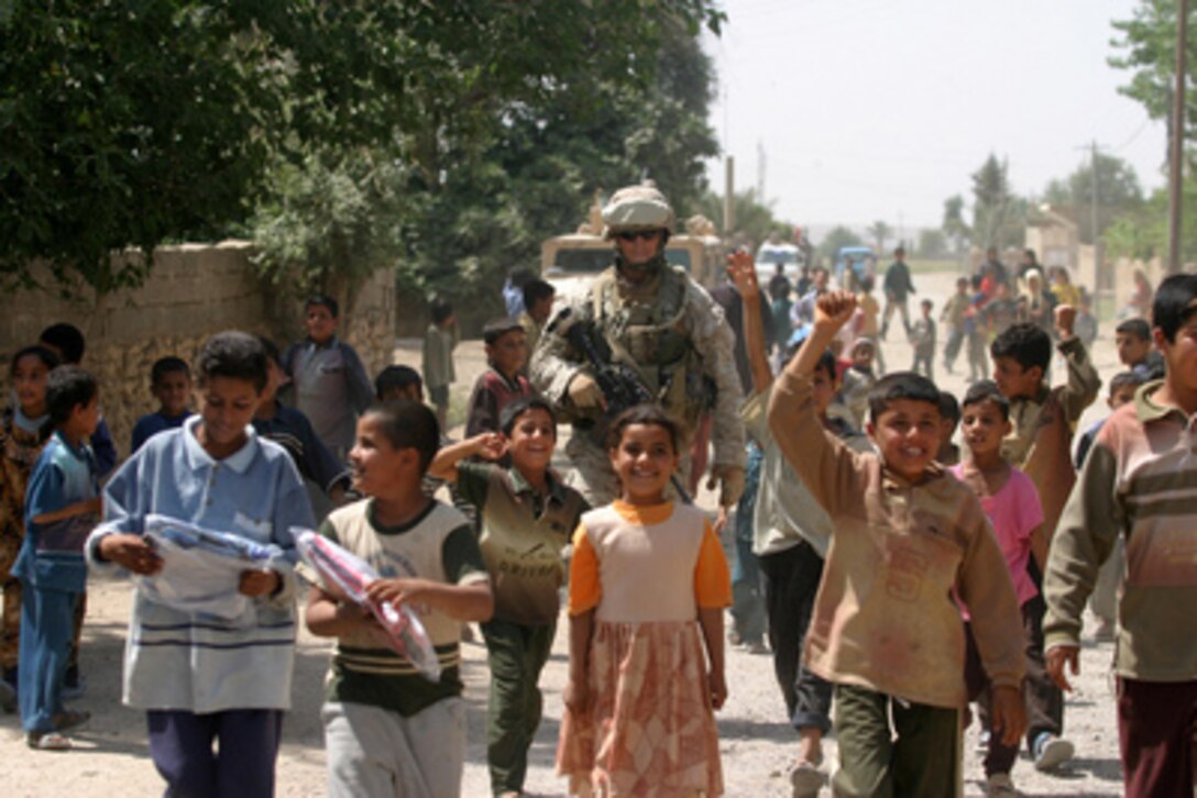 Iraqi children escort U.S. Marine Corps Cpl. Gregory A. Frank as he patrols in Al Ish, Iraq, on May 10, 2006. Frank is with Weapons Company, 1st Battalion, 7th Marine Regiment, I Marine Expeditionary Force. 