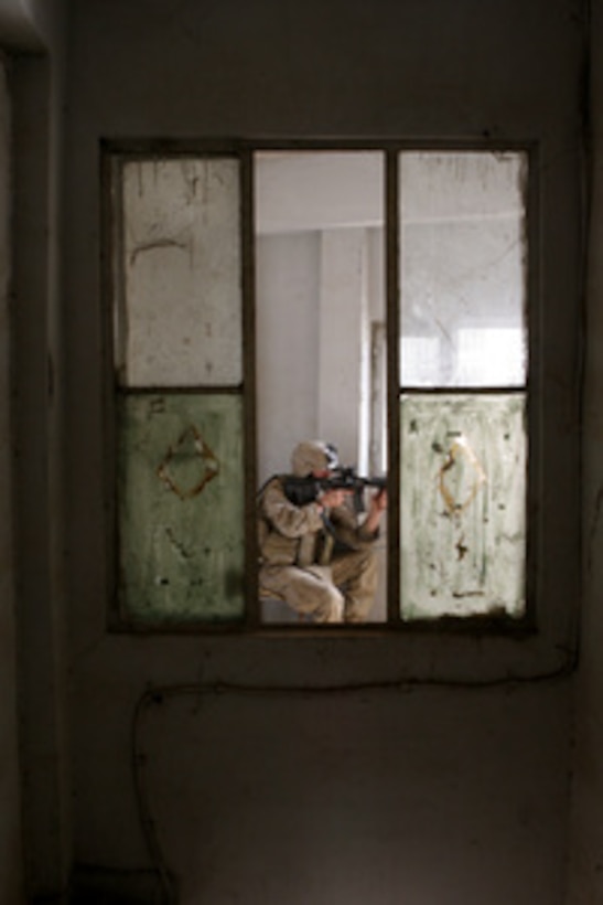 U.S. Marine Corps Lance Cpl. Rick Z. James scans the street while providing security in an abandon building in Ramadi, Iraq, on May 13, 2006. James is assigned to the 3rd Battalion, 8th Marine Regiment. 