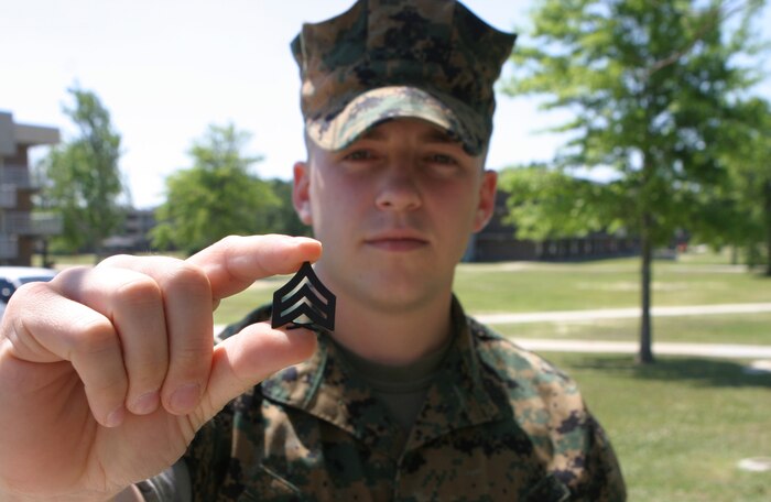 MARINE CORPS BASE CAMP LEJEUNE, N.C. (May 18, 2006) ? Sgt. Michael R. Albin holds up a sergeant chevron here May 18, that he earned after winning a meritorious sergeants board. His father who used to be a Marine, Ron, gave Albin the cheverons so he could have them pinned on. Albin is the staff noncommissioned officer-in-charge for the Deployed Support Administration Section, Service Company, Headquarters and Service Battalion, 2nd Marine Logistics Group.