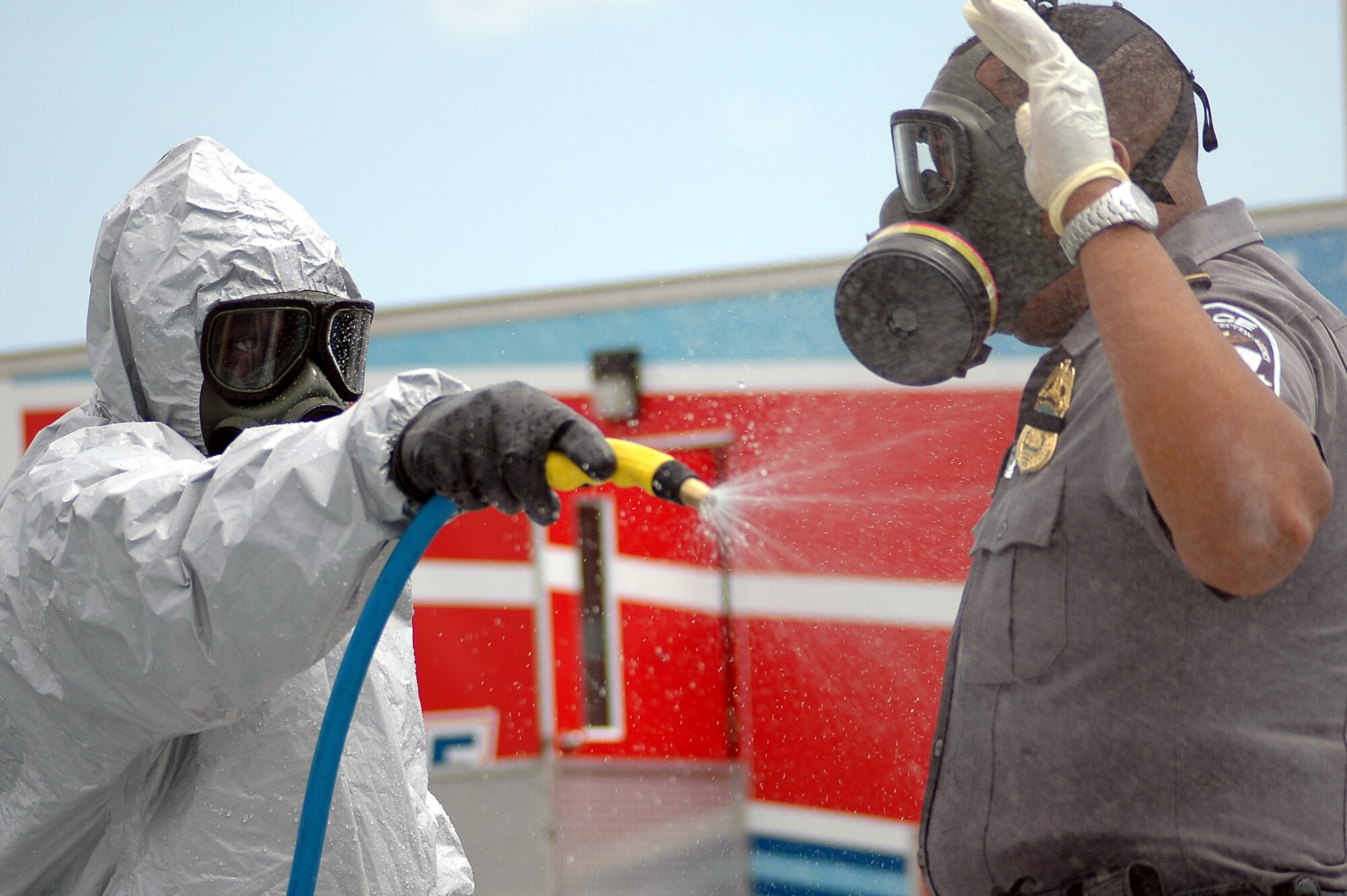 A member of the Pentagon Force Protection Agency is decontaminated during an exercise at the Pentagon on Wednesday, May 17, 2006.  During exercise Gallant Fox 06, officials from Washington D.C. area fire, emergency medical service, and police departments; military members; and members of the Pentagon Force Protection Agency participated in the exercise, which included decontamination and medical processing of victims of a simulated anthrax attack at the Pentagon.  (U.S. Air Force photo/Staff Sgt. C. Todd Lopez) 