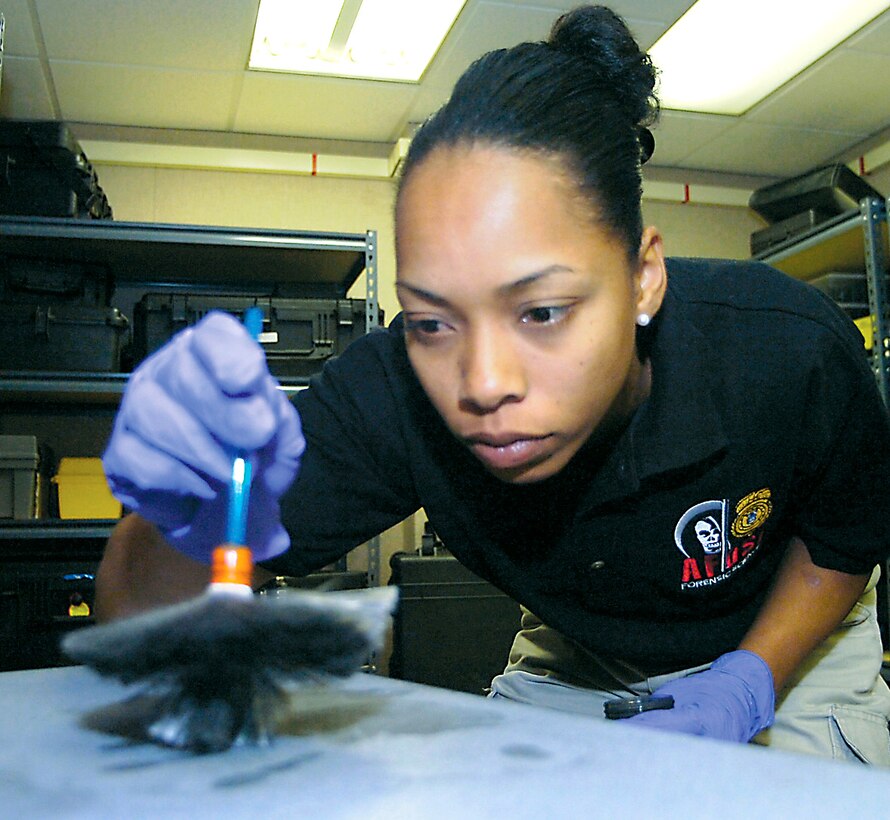 Special Agent Tam Reed dusts a crime scene area for fingerprints. She is a forensic science consultant with the Air Force Office of Special Investigations' 33rd Field Investigations Squadron.  (U.S. Air Force photo/Bobby Jones)