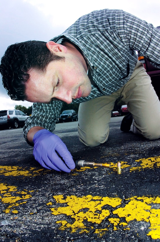 Special Agent Jeremy Gage deposits a gluing agent on a bullet shell to preserve a fingerprint on the shell. Agent Gage is a forensic science consultant with the Air Force Office of Special Investigations' 33rd Field Investigations Squadron. (U.S. Air Force photo/Bobby Jones)