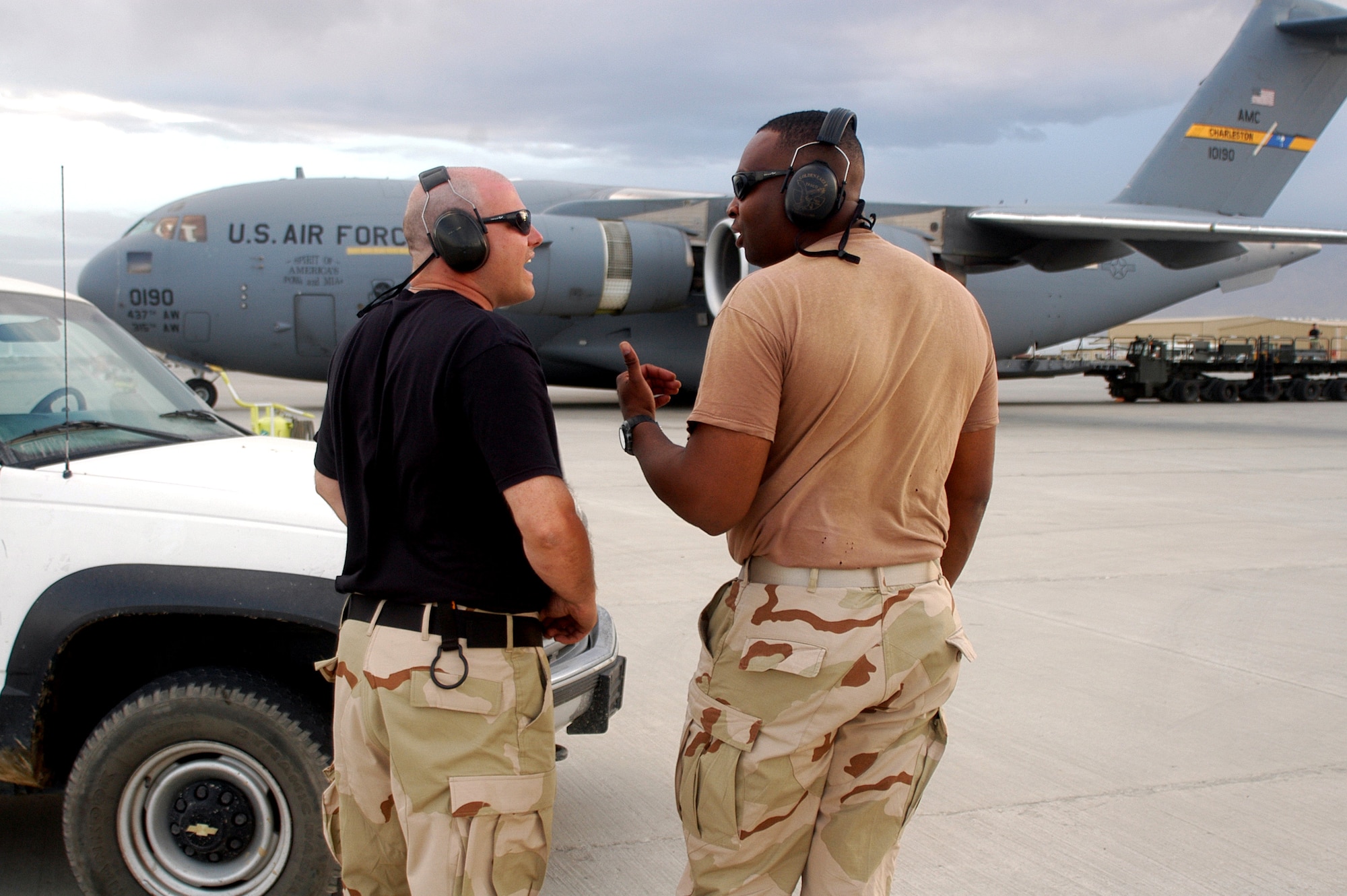 Staff Sgt. Gordon Torrey (left) and Tech. Sgt. Michael Leach coordinate aircraft parking on the ramp, having just parked a C-17 Globemaster III delivering cargo on Tuesday, May 16, 2006, to Bagram Air Base, Afghanistan.  The two sergeants are crew chiefs in the transient alert section of the 455th Expeditionary Maintenance Squadron, deployed here in support of Operation Enduring Freedom.  (U.S. Air Force photo/Maj. David Kurle)