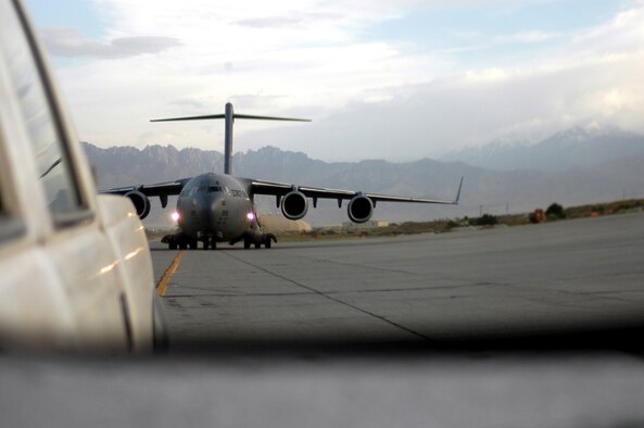Seen in the rearview mirror of a "follow me" truck, a C-17 Globemaster III is guided to a parking spot at Bagram Air Base, Afghanistan, on Tuesday, May 16, 2006.  The transient alert section of the 455th Expeditionary Maintenance Squadron has the dubious task of finding parking spots for some 650 aircraft per month that fly cargo and passengers into the air base in support of Operation Enduring Freedom.  (U.S. Air Force photo/Maj. David Kurle)