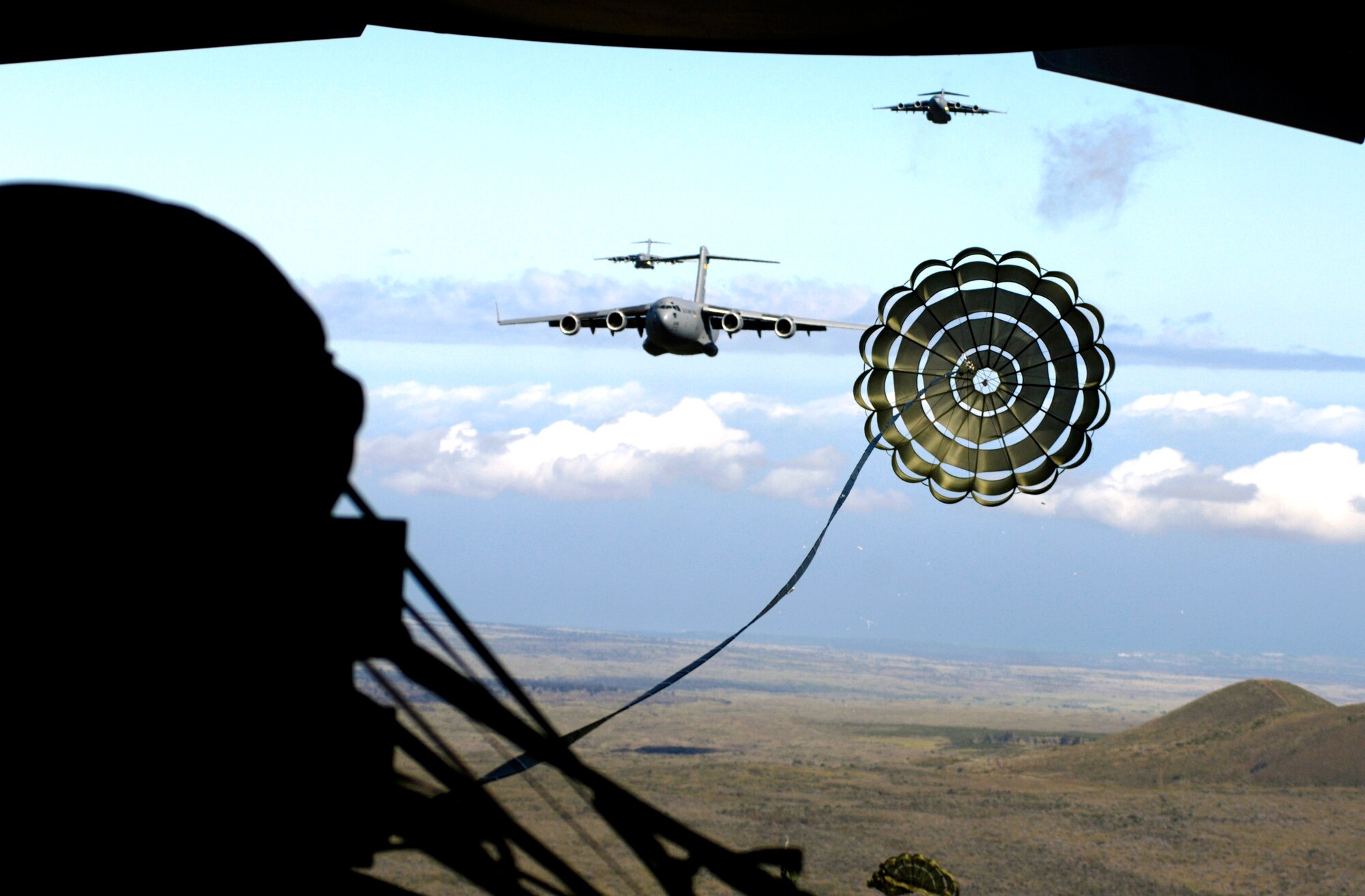 An extraction chute opens over the drop zone during an airdrop training mission May 16, 2006. The C-17 Globemaster IIIs are from the 535th Airlift Squadron, Hickam Air Force Base, Hawaii and are conducting the training to provide multi-element training for the pilots and maintain aircrew proficiency. (U.S. Air Force photo/Tech. Sgt. Shane A. Cuomo) 