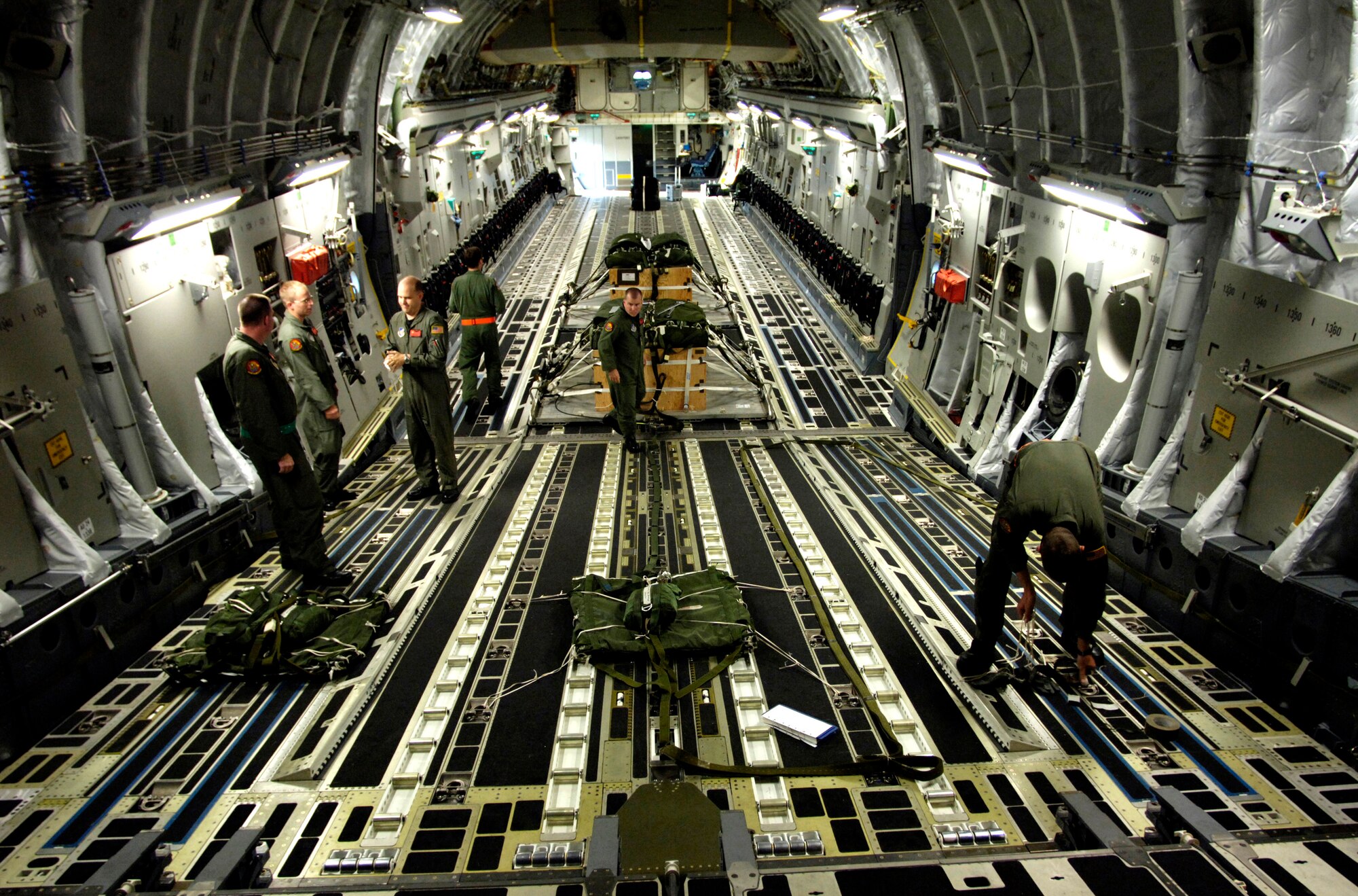 C-17 Globemaster III aircrew members prepare the rigging for parachutes for an upcoming airdrop training mission May 16, 2006, at Hickam Air Force Base, Hawaii. The aircrew members are from the 535th Airlift Squadron. The training provides multi-element training for the pilots enables users to get larger amounts of equipment in a short period of time and maintains aircrew proficiency. (U.S. Air Force photo/Tech. Sgt. Shane A. Cuomo) 

