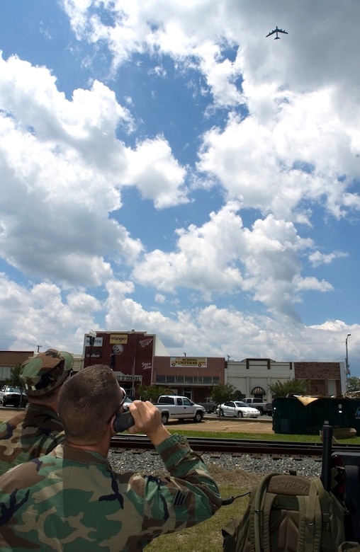 Senior Airman Chris Kenck, a joint terminal air controller assigned to Detachment 1, 458th Combat Training Squadron, Fort Polk, La., talks the pilot of a B-52 Stratofortress from Barksdale, AFB, La., flying overhead.  Airman Kenck is calling in a target during urban combat air support training on May 16, 2006.  The training took place in Deridder, La., where the 458th has an agreement to allow flights over the city for more realistic urban conditions. (U.S. Air Force Photo/Master Sgt. Jack Braden)