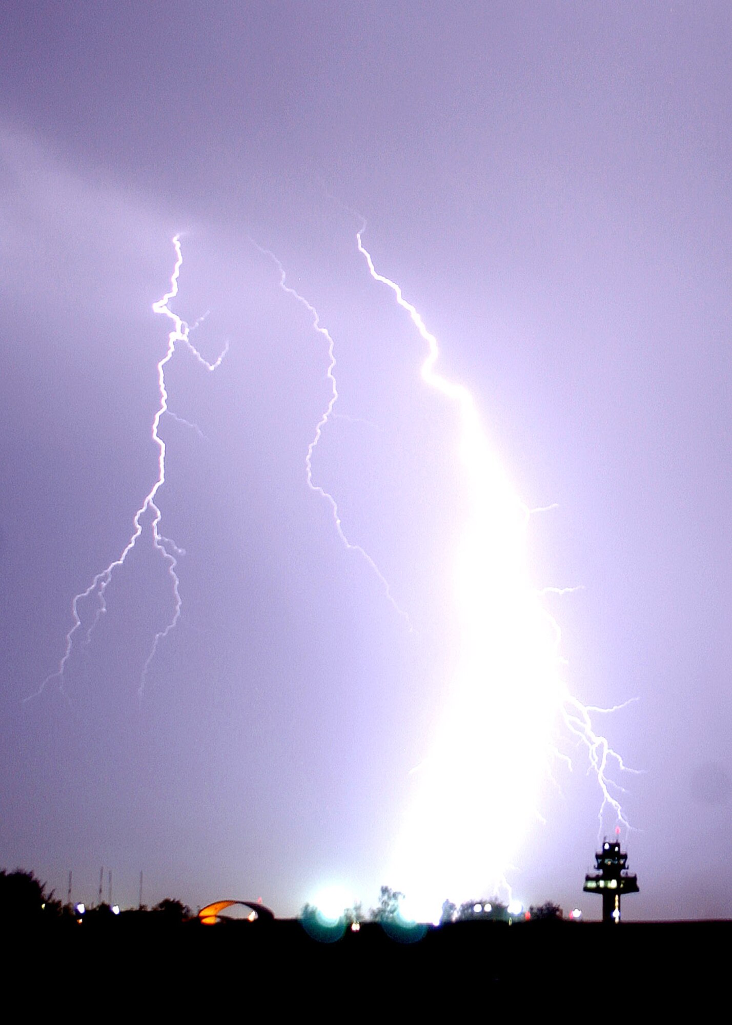 Lightning strikes near the control tower and a taxing C-130 Hercules at Balad Air Base, Iraq, on Tuesday, May 16, 2006. Balad handles more than 750 cargo flights each month and is the Department of Defense's busiest single runway. Using C-130s to fly in-theater airlift missions has reduced the number of ground convoys and troops exposed to roadside bomb attacks. (U.S. Air Force photo/Senior Airman James Croxon)       