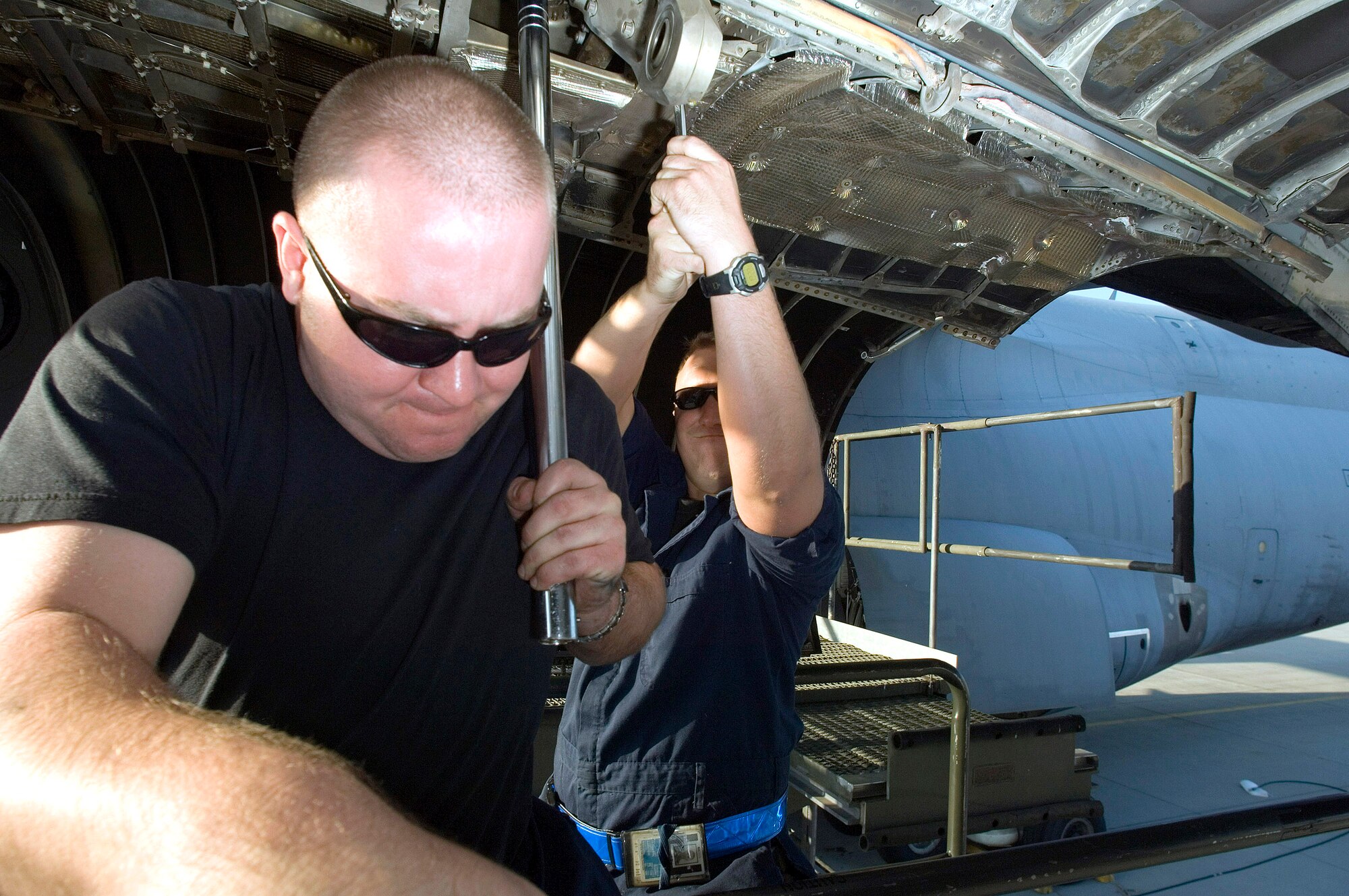 Staff Sgts. Steve Fields (left) and Matthew Lockwood exchange engine anchors on a C-5 Galaxy while replacing a damaged engine on May 11, 2006 at Ramstein Air Base, Germany. Sergeant Fields, from Stockton, Calif., is a jet engine mechanic and Sergeant Lockwood, from Redding, Calif., is a crew chief. Both are assigned to the 723rd Air Mobility Squadron. (U.S. Air Force photo/Master Sgt. John E. Lasky) 