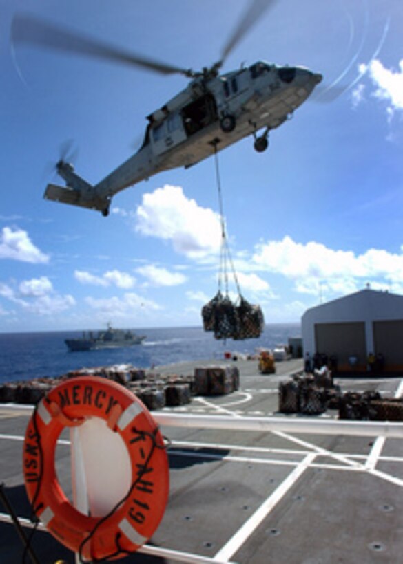 An MH-60S Seahawk helicopter delivers supplies to the Military Sealift Command hospital ship USNS Mercy (T AH 19) during a vertical replenishment with the USNS Concord (T AFS 5) in the Pacific Ocean on May 14, 2006. The Mercy is on a five-month deployment to areas of Southeast Asia to join with health and civic organizations to provide humanitarian assistance and conduct community improvement projects. 