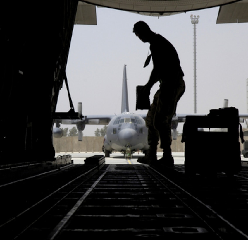 U.S. Air Force Tech. Sgt. Sean Fox changes the cargo roller configuration of a C-130 Hercules aircraft at Balad Air Base, Iraq, on May 16, 2006. Fox is assigned to the 777th Expeditionary Aircraft Maintenance Unit. 