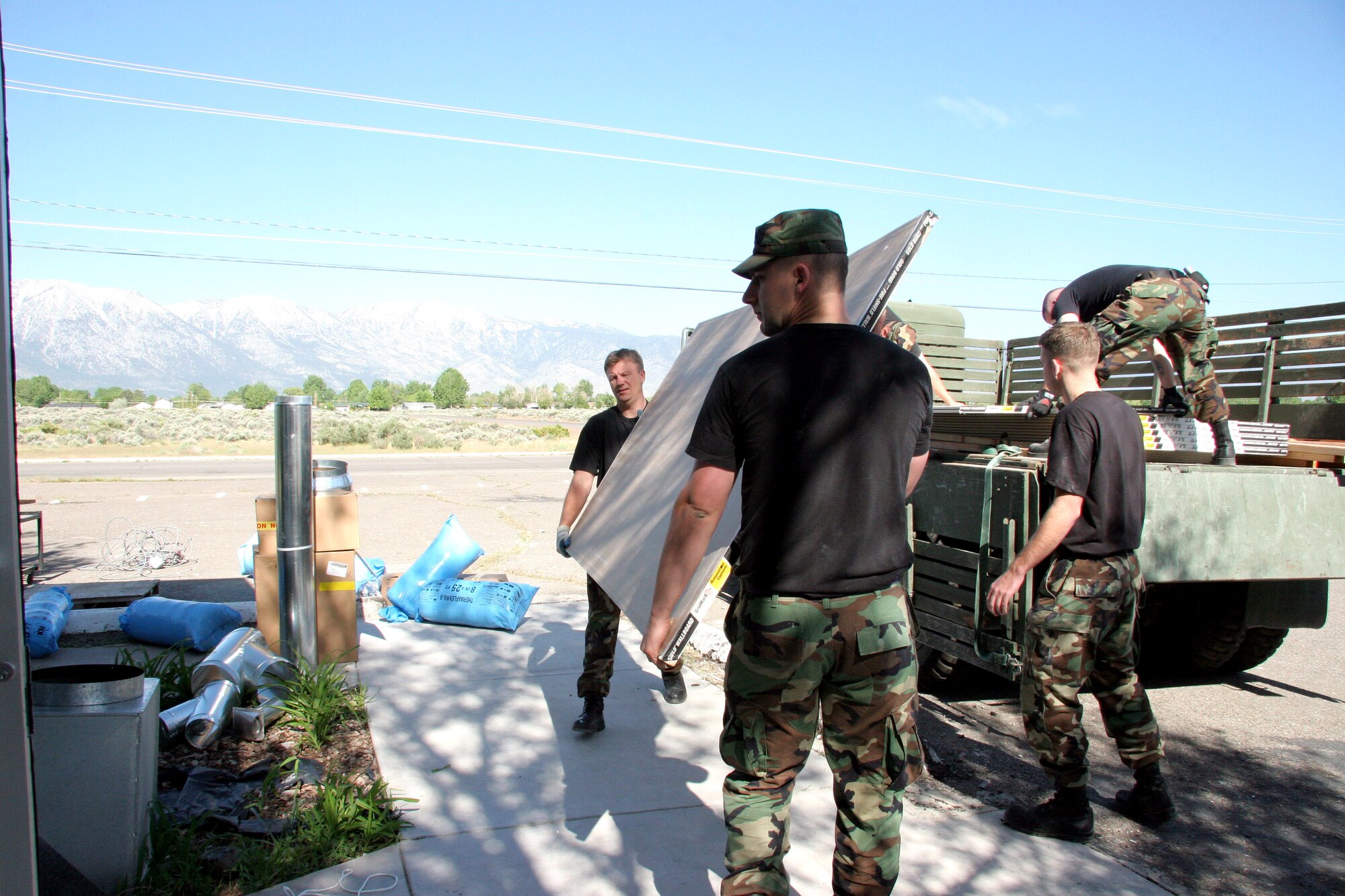 Senior Master Sgt. Steve Watson and Airman 1st Class Jason Jackson carry sheet rock into an old store being converted into a wellness center for the Washoe American-Indian Tribe as part of an Air Force Reserve Command innovative readiness training program near Carson City, Nev. May 16, 2006. Sergeant Watson is a utilities superintendent. Airman Jackson is a utilities apprentice. Both are with the 939th Civil Engineer Squadron. (U.S. Air Force Photo/Ruby Zarzyczny)