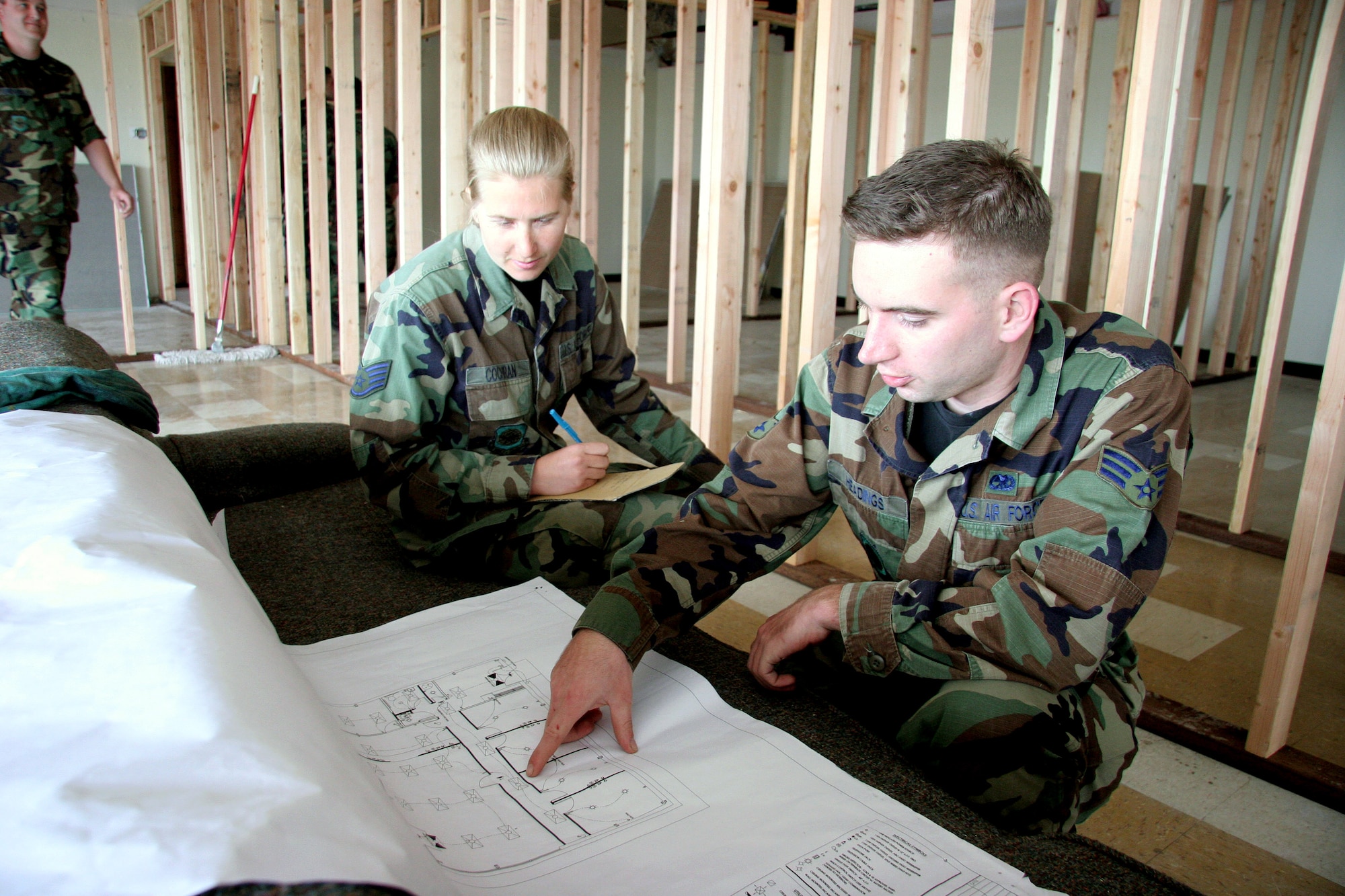 Staff Sgt. Karla Cochran and Senior Airman Daniel Headings review the construction plans for the tribal wellness center on the Washoe Indian Reservation near Carson City, Nev. May 15, 2006. They will be running electrical, phone, cable and internet wires throughout the building as part of an Air Force Reserve Command innovative readiness training program. Both are electricians with the 939th Civil Engineering Squadron. (U.S. Air Force Photo/Ruby Zarzyczny)