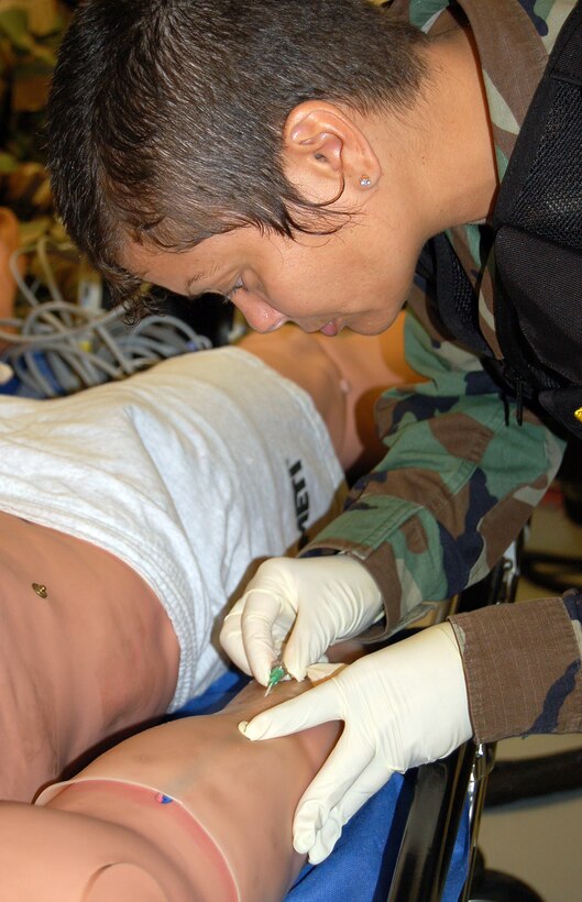Staff Sgt. Suellen Carire inserts a needle into the arm of her unique patient, a computerized mannequin, during a new Air Force Special Operations Command casualty evacuation course on Thursday, May 18, 2006.  The realistic training is geared to better prepare medics for the chaos of combat operations.  Sergeant Carire is from the 920th Rescue Wing, Patrick Air Force Base, Fla., and was among the first students to attend the new course.  (U.S. Air Force photo/Master Sgt. Timothy P. Barela)