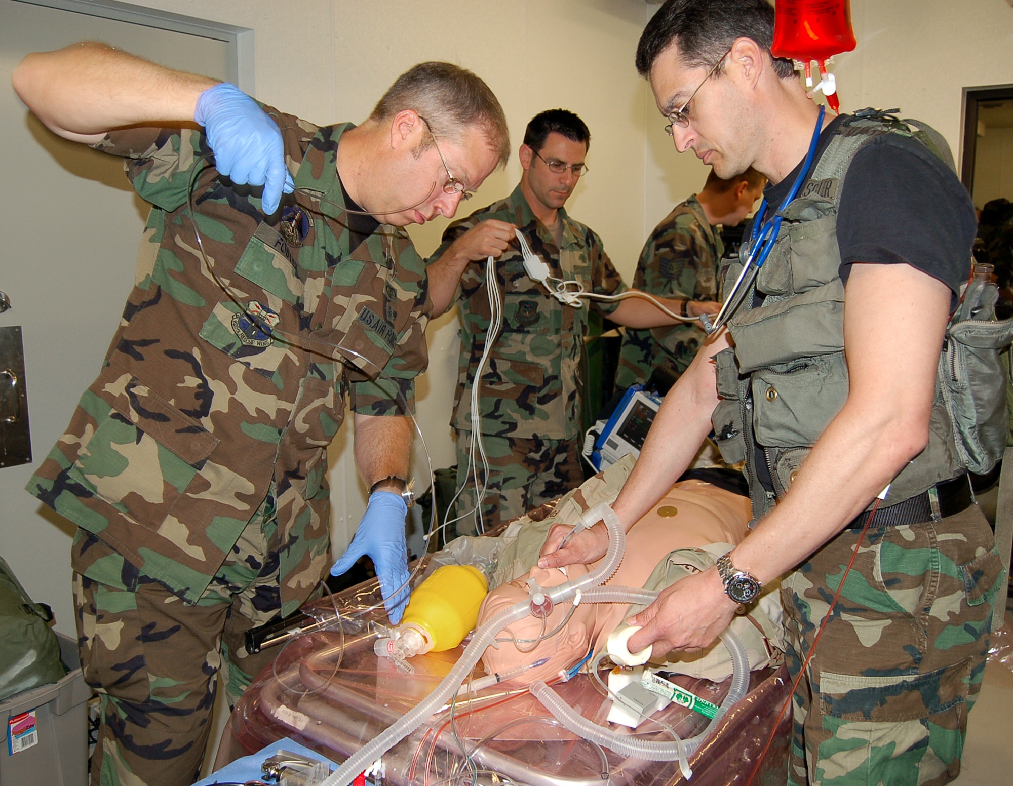 Clockwise from right, Master Sgt. John Schiller, and Tech. Sgts. Dave Foster, Robert Carcieri and Kirk Bobleter treat and stabilize their unique patient, a computerized mannequin, during a new Air Force Special Operations Command casualty evacuation course on Thursday, May 18, 2006.  The realistic training is geared to better prepare medics for the chaos of combat operations.  All four students are from the 920th Rescue Wing, Patrick Air Force Base, Fla., and were among the first Airmen to attend the new course.  (U.S. Air Force photo/Master Sgt. Timothy P. Barela)