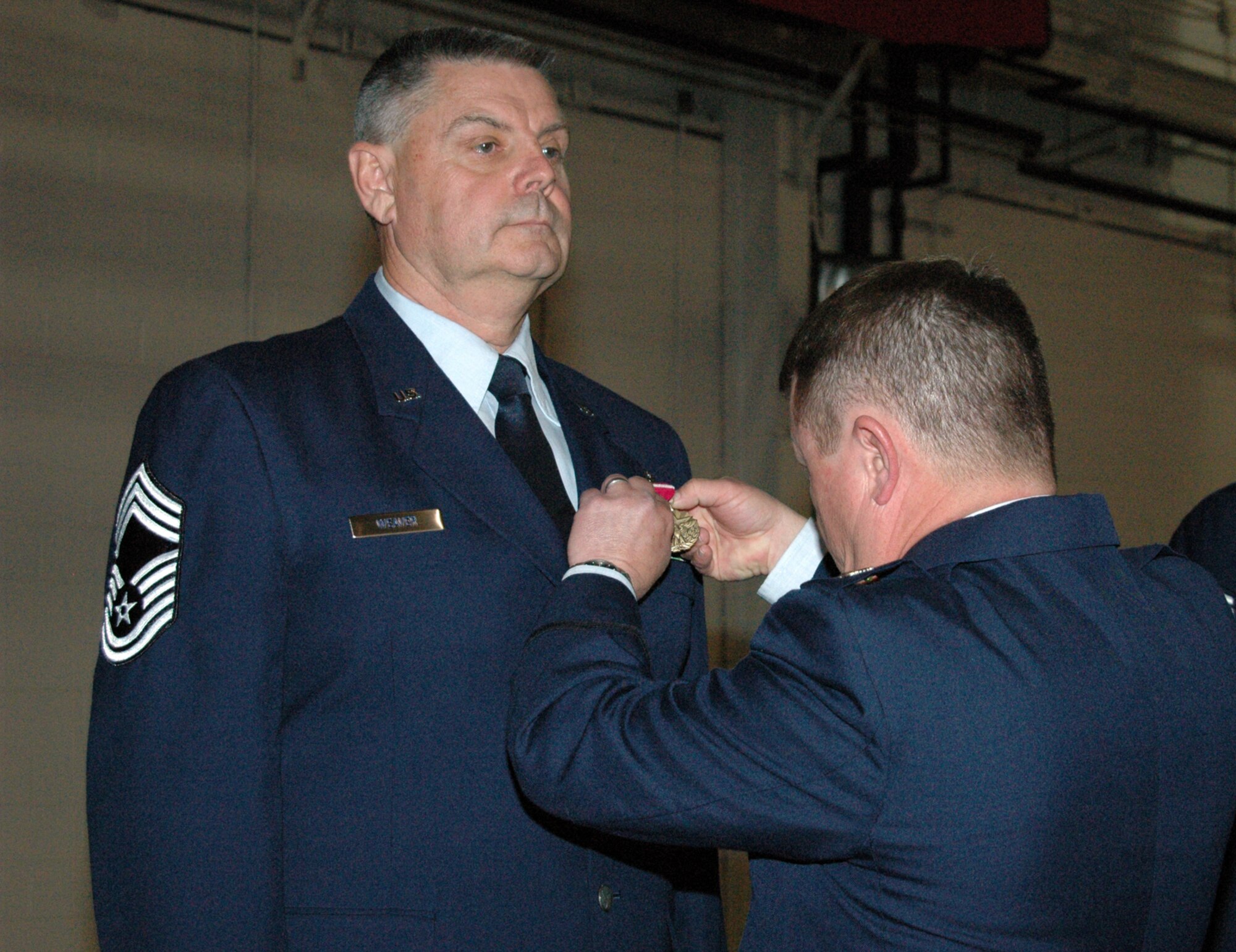 YOUNGSTOWN AIR RESERVE STATION, Ohio - Air Force Reserve Chief Master Sgt. David L. Weaver, superintendent of the 910th Maintenance Squadron, retired May 6 with nearly 40 years of service to the Air Force and Air Force Reserve.  Col. Timothy J. Thomson, commander of the 910th Airlift Wing, pins the Air Force Meritorious Service Medal on Chief Weaver during his retirement ceremony.  (U.S. Air Force photo/Master Sgt. Bryan Ripple)