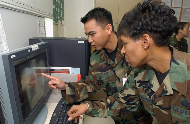 Staff Sgt. Joie Manog, diagnostic imaging quality control monitor, shows Chief Master Sgt. Carol Johnson, 60th Air Mobility Wing interim command chief, chest X-rays. (U.S. Air Force photo by Andre Mansour)