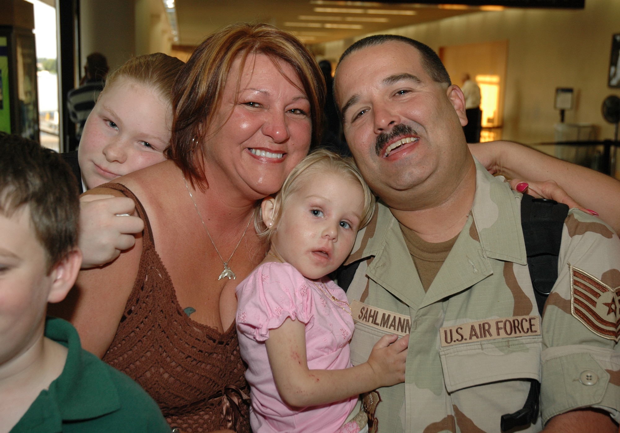 Tech. Sgt. John Sahlmann, a reservist assigned to the 81st Aerial Port Squadron at Charleston AFB, S.C., hugs his family after arriving at the Charleston International Airport from a 4-month deployment in Kuwait.  (Photo by 1st Lt. Wayne Capps)