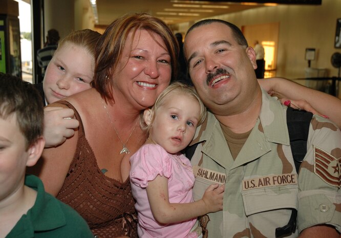 Tech. Sgt. John Sahlmann, a reservist assigned to the 81st Aerial Port Squadron at Charleston AFB, S.C., hugs his family after arriving at the Charleston International Airport from a 4-month deployment in Kuwait.  (Photo by 1st Lt. Wayne Capps)