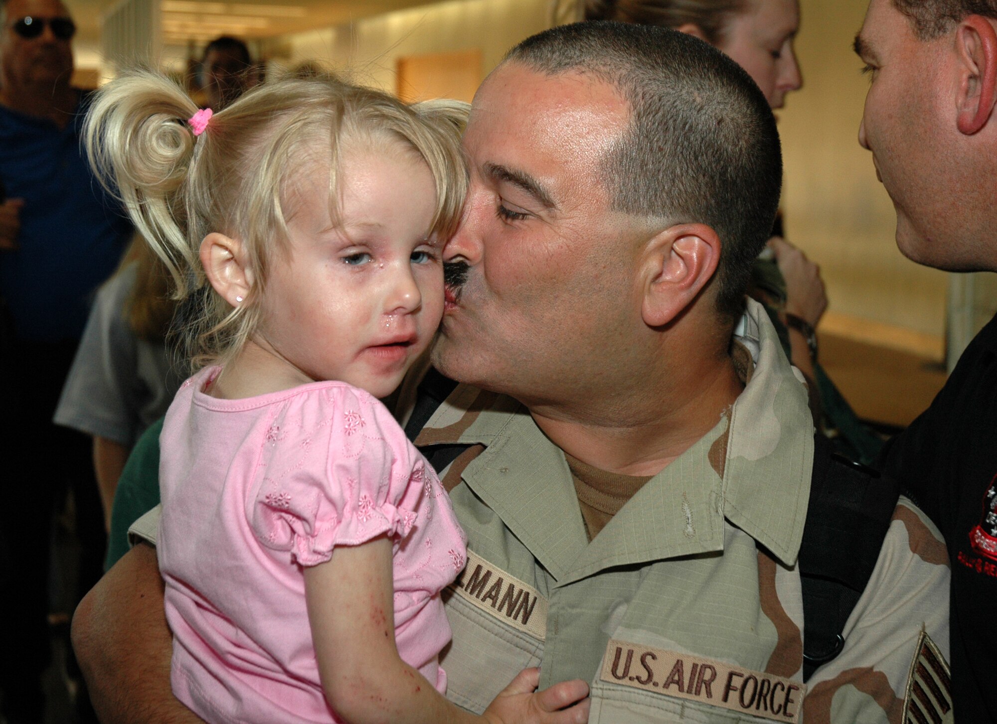 Tech. Sgt. John Sahlmann, a reservist assigned to the 81st Aerial Port Squadron at Charleston AFB, S.C., kisses his daughter after arriving at the Charleston International Airport from a 4-month deployment in Kuwait.  (Photo by 1st Lt. Wayne Capps)