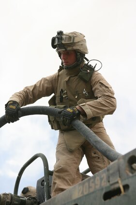 Standing atop a fuel truck, Lance Cpl. Brian K. Martin, a motor transport operator with Combat Logistics Company 115 and 21-year-old native of Anderson, S.C., feeds a fuel hose to a fellow Marine during a generator refueling mission May 20, 2006. In addition to providing fuel for American and Iraqi forces, the company, a part of Combat Logistics Battalion 5, provides other crucial supplies to service members in the Fallujah area; they have traveled in excess of 65,000 miles since arriving here three months ago.