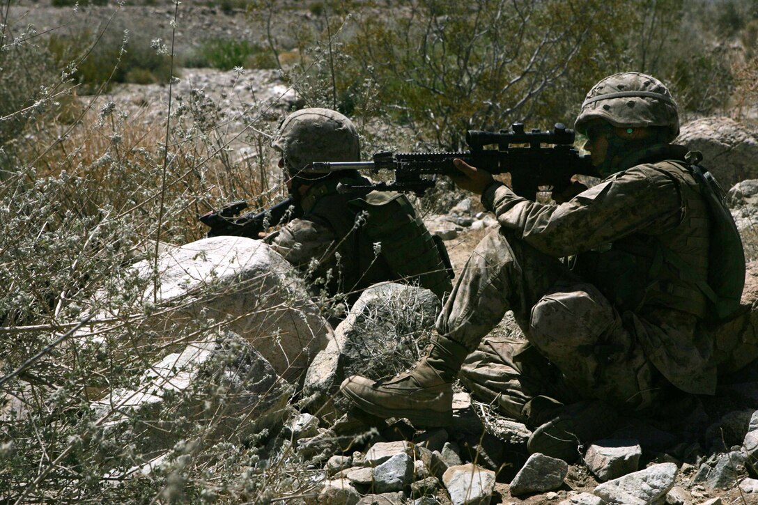 Lance Cpl. Jesse A. Lauch (Front), a designated marksman for Company B, 1st Battalion, 6th Marine Regiment, and Lance Cpl. Michael J. Howard, team leader for Company B, provide security while waiting to maneuver during a live-fire, company assault exercise aboard Marine Corps Air Ground Combat Center Twentynine Palms, May 20.