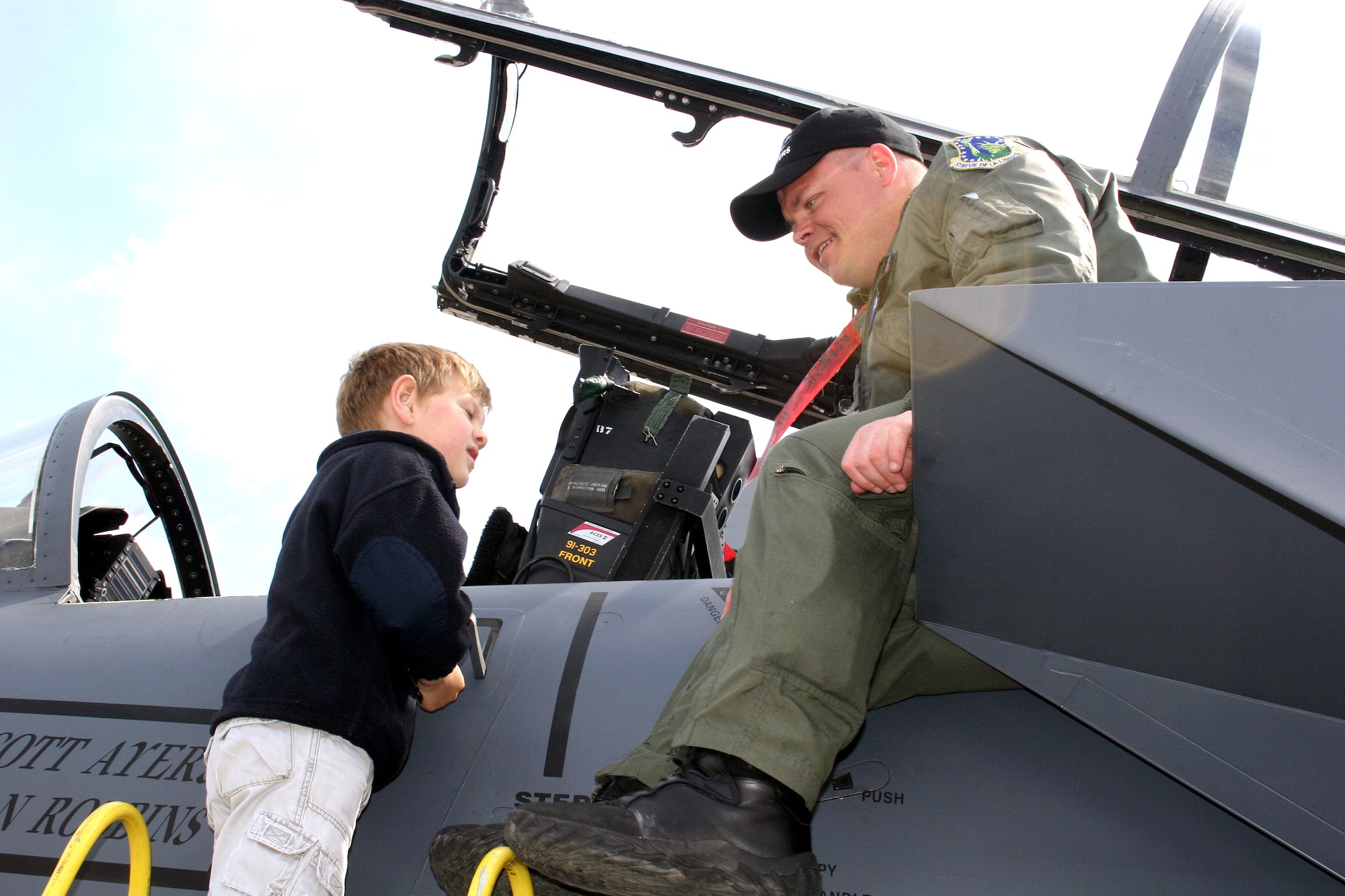 Capt. D. J. Vollmer talks with a young visitor from atop an F-15E Strike Eagle on May 20, 2006, at the Berlin Air Show at Berlin-Schoenefeld Airport. Captain Vollmer is a weapons systems officer with the 492nd Fighter Squadron at Royal Air Force Lakenheath, England. From May 19 to 21, 120,000 people visited the air show, which promoted the goals of enhancing interoperability among U.S. allies as well as the commitment to the preservation of Europe's security. (U.S Air Force photo/Maj. Pamela A.Q. Cook)