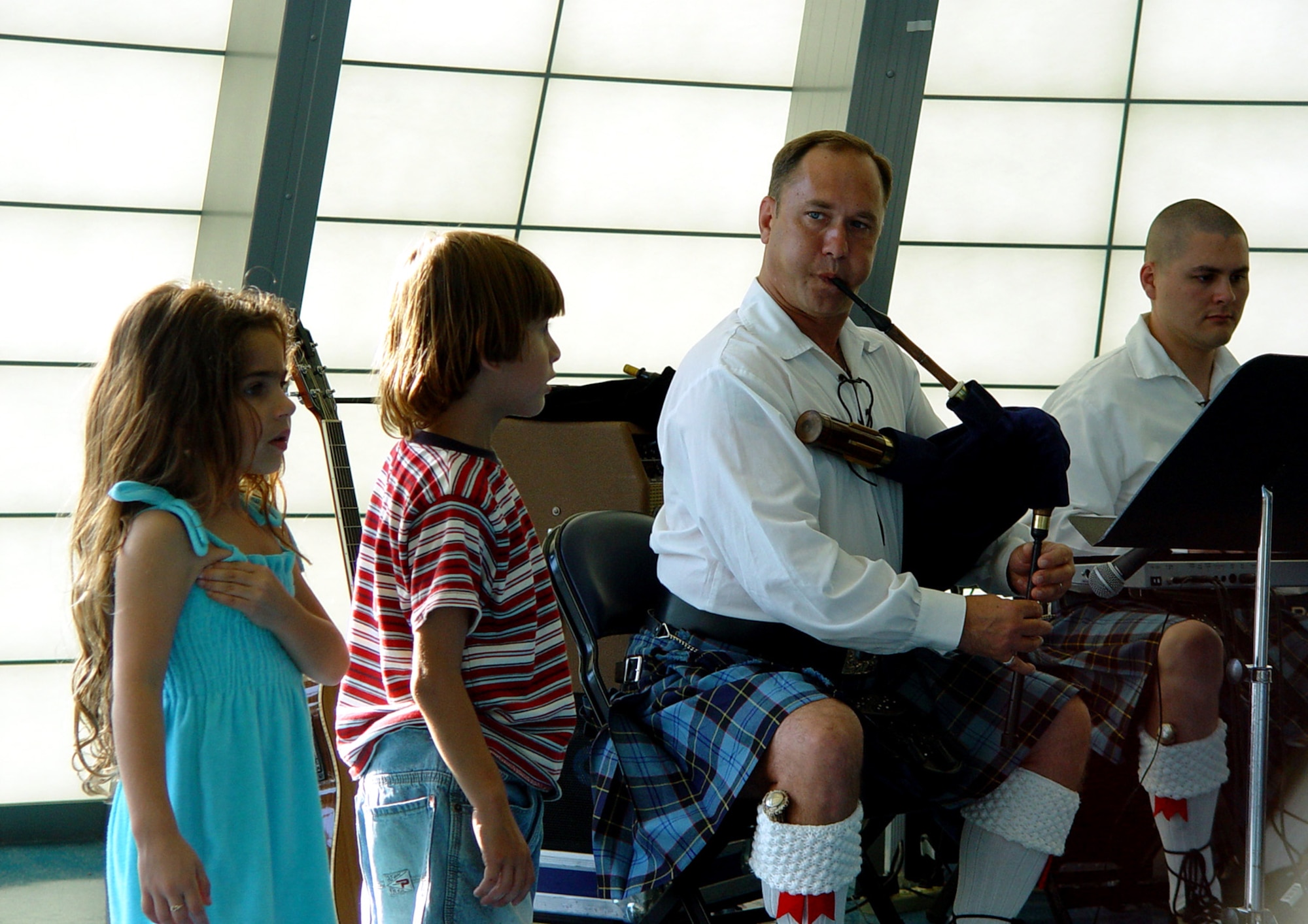 Master Sgt. Scott Gunn and Senior Airman Tim Shaw, members of the Band of the Air Force Reserve's Celtic ensemble, Southern Aire, perform at the Miami Children's Museum on May 19, 2006, as two children look on.  The Band of the Air Force Reserve, from Robins Air Force Base, Ga., performed nine times in South Florida as part of a community outreach project. (U.S. Air Force photo/Lisa Macias)