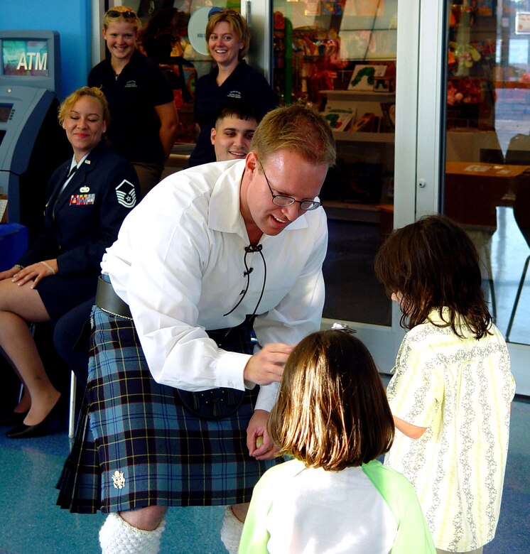 Senior Airman Mike Henrie, a member of the Band of the Air Force Reserve's Celtic ensemble, Southern Aire, shows two little girls how to use one of his percussion instruments during a performance at Miami Children's Museum on May 19, 2006.   The Band of the Air Force Reserve, from Robins Air Force Base, Ga., performed nine times in South Florida as part of a community outreach project. (U.S. Air Force photo/Lisa Macias)