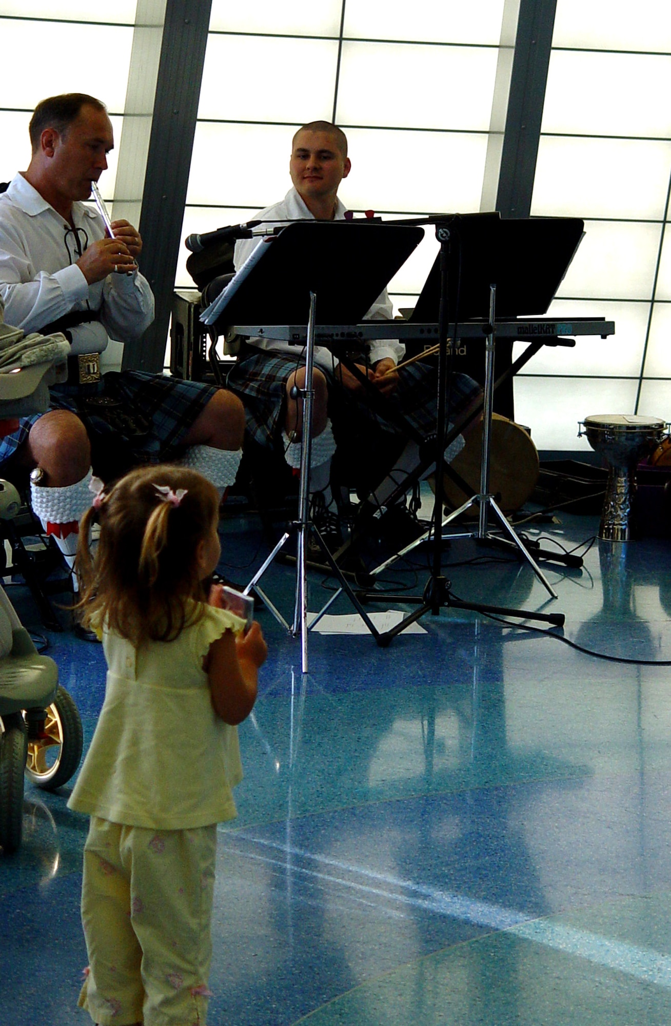 Master Sgt. Scott Gunn and Senior Airman Tim Shaw, members of the Band of the Air Force Reserve's Celtic ensemble, Southern Aire, perform at the Miami Children's Museum on May 19, 2006, as 2 year old Brianna Page looks on.  The Band of the Air Force Reserve, from Robins Air Force Base, Ga., performed nine times in South Florida as part of a community outreach project. (U.S. Air Force photo/Lisa Macias)
