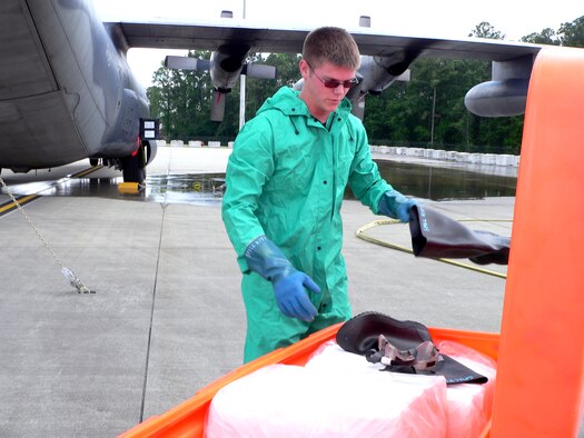 Senior Airman Shawn Buck grabs rubber boots during a mock fuel spill on the Moody Air Force Base, Ga., flightline on Wednesday, May 17, 2006.  The simulated spill was one of the scenarios during a hurricane evacuation exercise in preparation for the upcoming hurricane season.  Airman Buck is crew chief with the 347th Aircraft Maintenance Squadron.  (U.S. Air Force photo/Senior Airman S.I. Fielder)