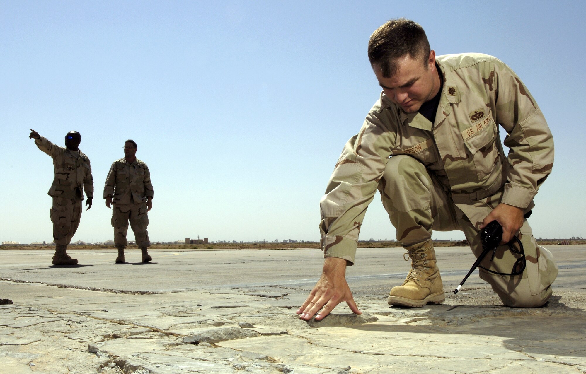 Maj. Matthew Jefson inspects a cracked and damaged section of runway at Balad Air Base, Iraq, on Friday, May 19, 2006.  The Air Force along with contractors and the U.S. Army Corps of Engineers are working to replace the section of runway.  The extensive damage was causing the runway to break apart and create foreign object debris.  More than 1,000 meters of the runway will be replaced.  Major Jefson is a project manager for the U.S. Central Command Air Forces' construction management office.  (U.S. Air Force photo/Senior Airman Brian Ferguson)